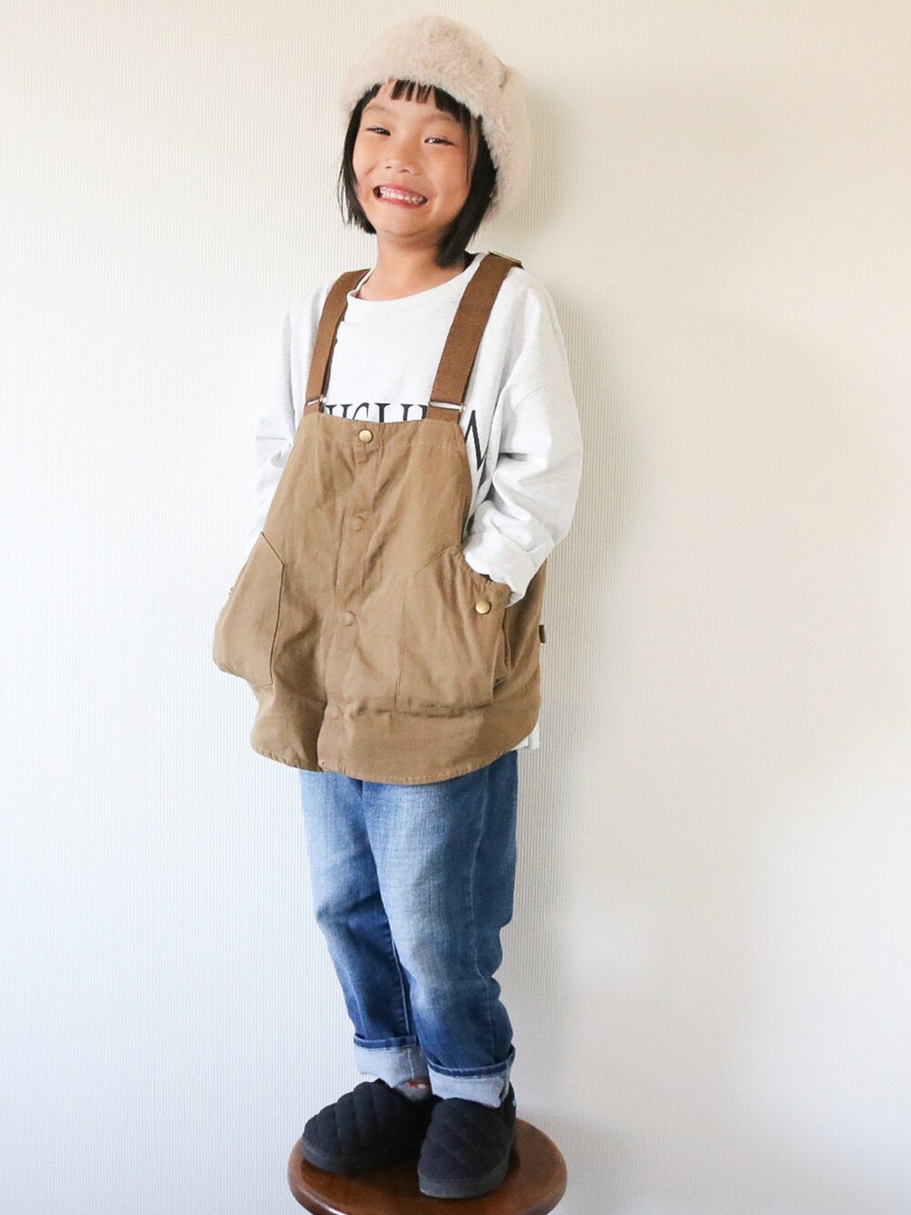 グレー系のTシャツ/カットソー、ベージュ系のベスト、ブラック系のスニーカーを着用したキッズの秋コーディネートの2枚目の写真