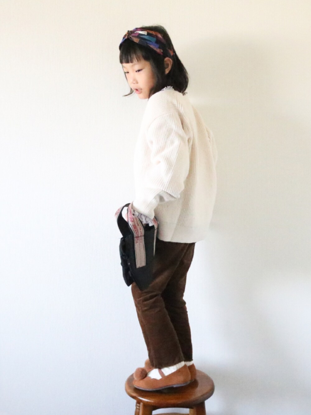 ホワイト系のカーディガン/ボレロ、ブラウン系のその他パンツを着用したキッズの冬コーディネートの2枚目の写真
