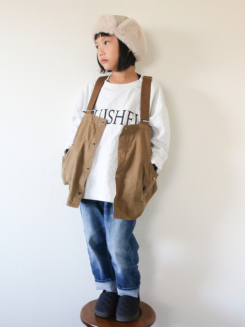 グレー系のTシャツ/カットソー、ベージュ系のベスト、ブラック系のスニーカーを着用したキッズの秋コーディネートの3枚目の写真