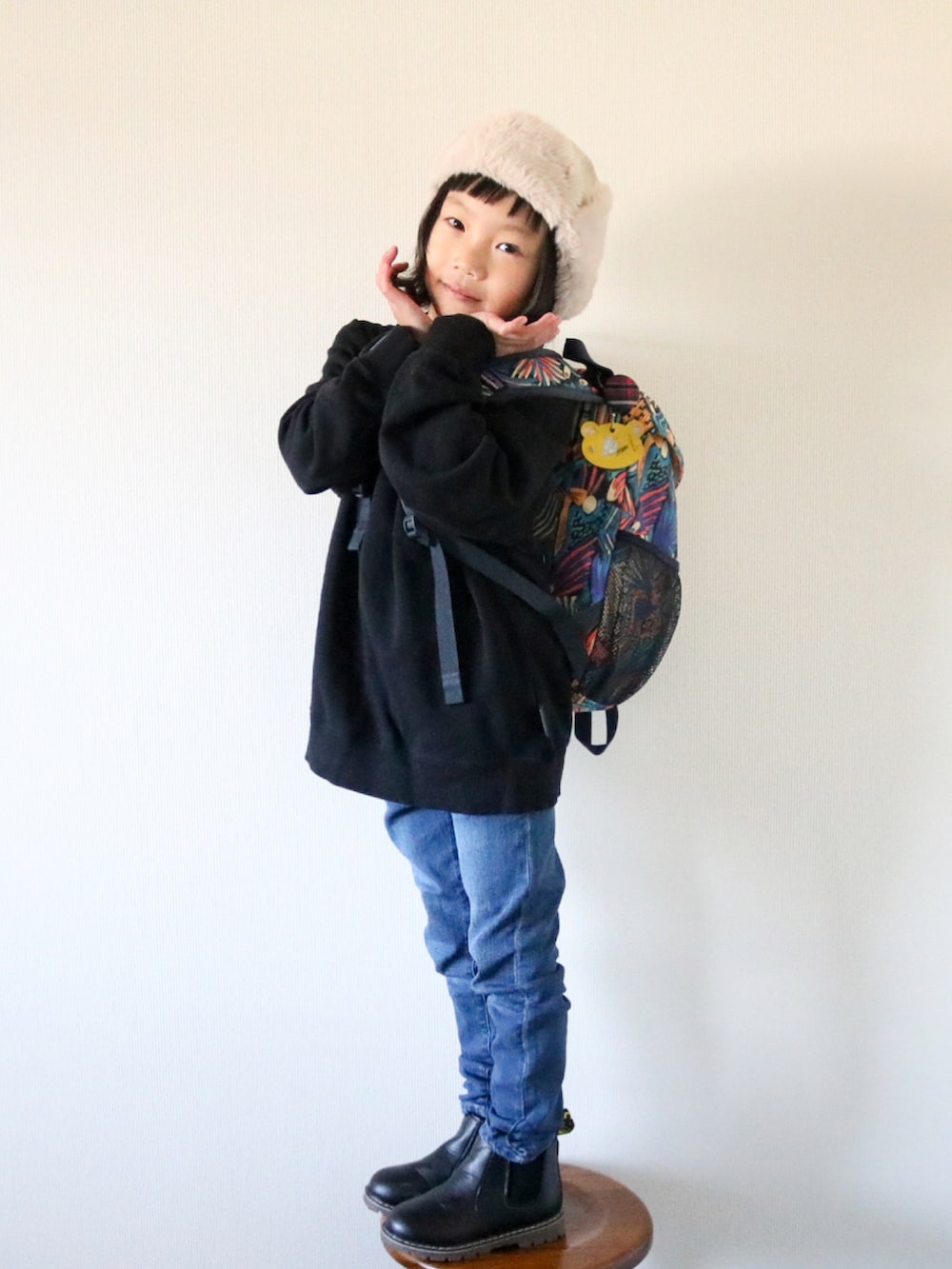 ブルー系のデニムパンツ、ブラック系のブーツ、ブラック系のスウェットを着用したキッズの冬コーディネートの2枚目の写真