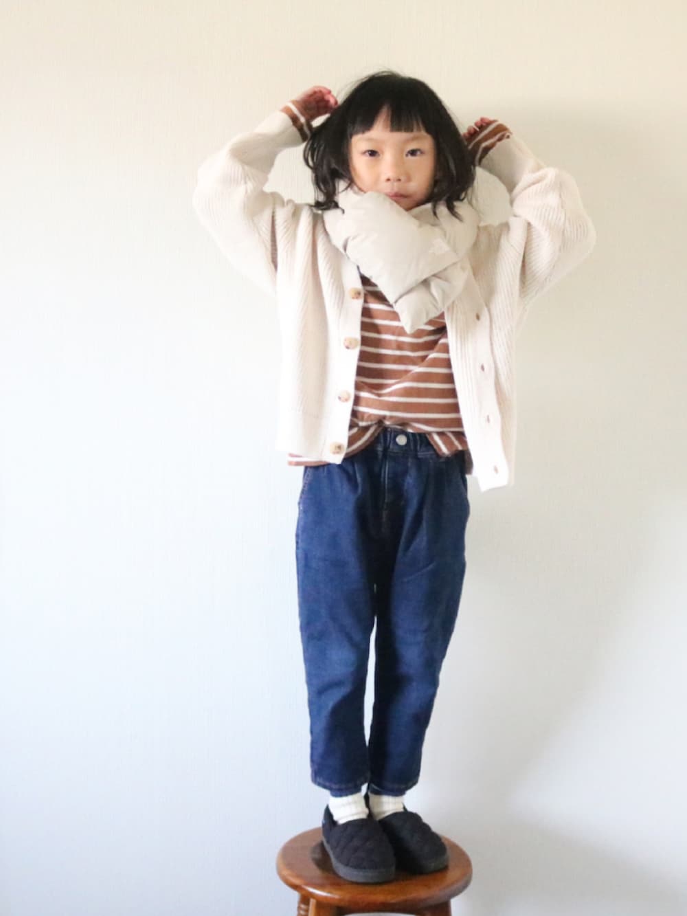 ブラウン系のTシャツ/カットソー、ホワイト系のカーディガン/ボレロ、ブラック系のスニーカーを着用したキッズの冬コーディネートの2枚目の写真