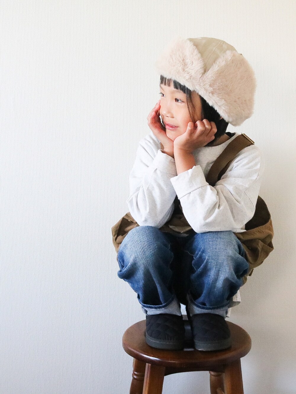 グレー系のTシャツ/カットソー、ベージュ系のベスト、ブラック系のスニーカーを着用したキッズの秋コーディネートの4枚目の写真