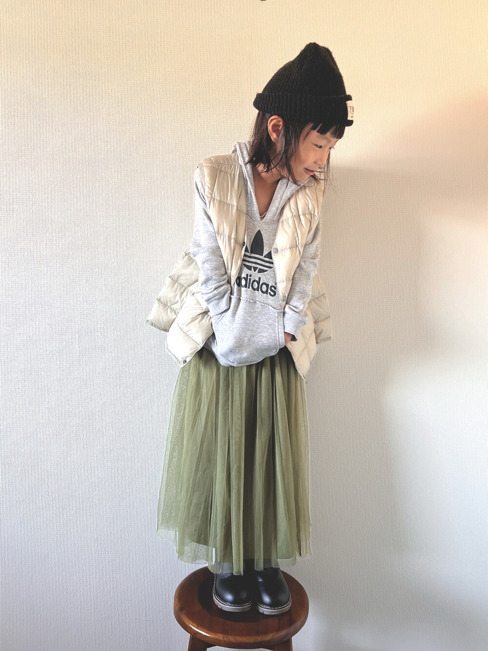 ベージュ系のベスト、グリーン系のパンツ、グレー系のトップスを着用したキッズの冬コーディネートの2枚目の写真