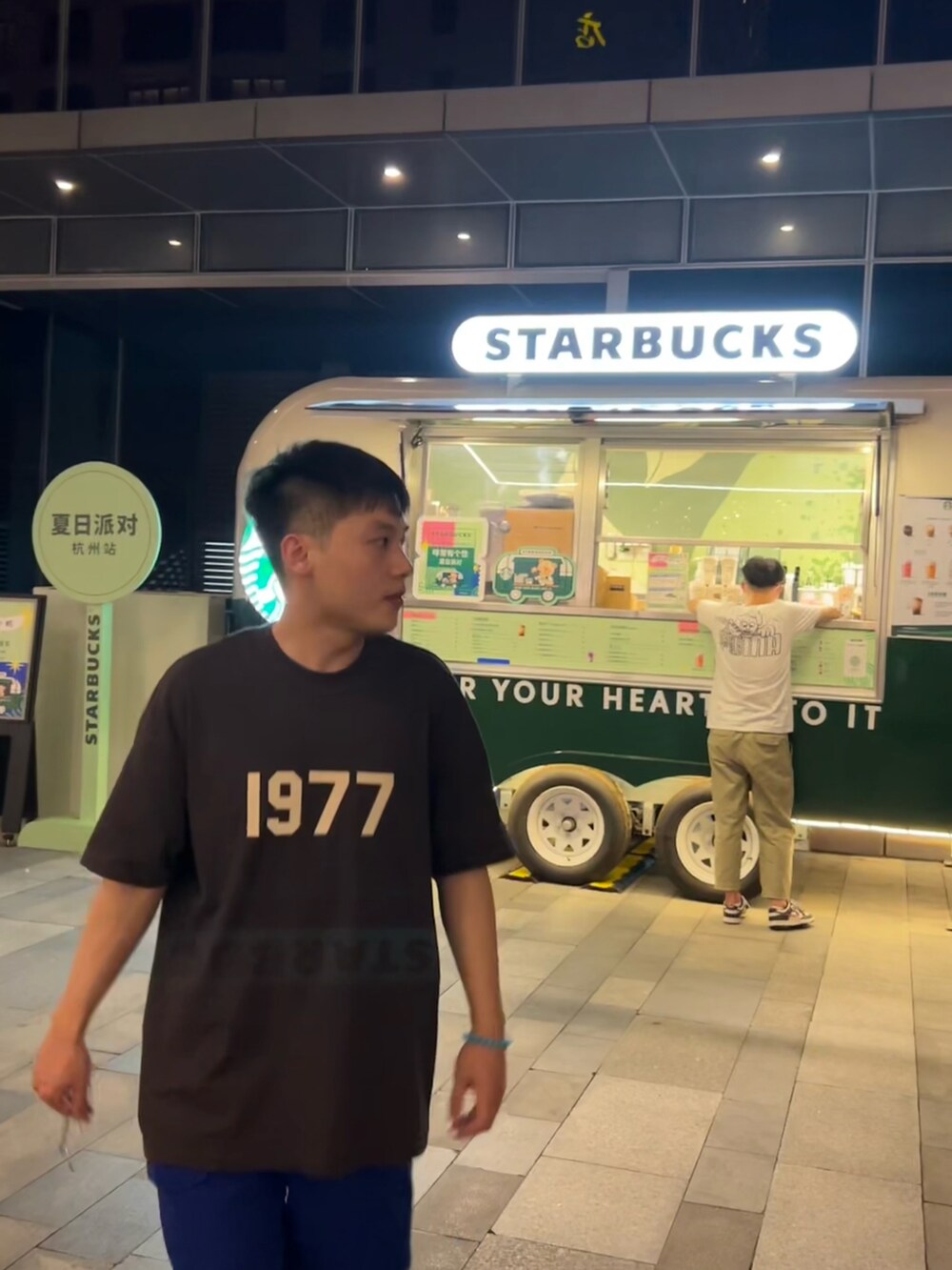 ホワイト系のスニーカー、ブルー系のカーゴパンツ、ホワイト系のTシャツ/カットソーを着用したメンズの夏コーディネートの2枚目の写真