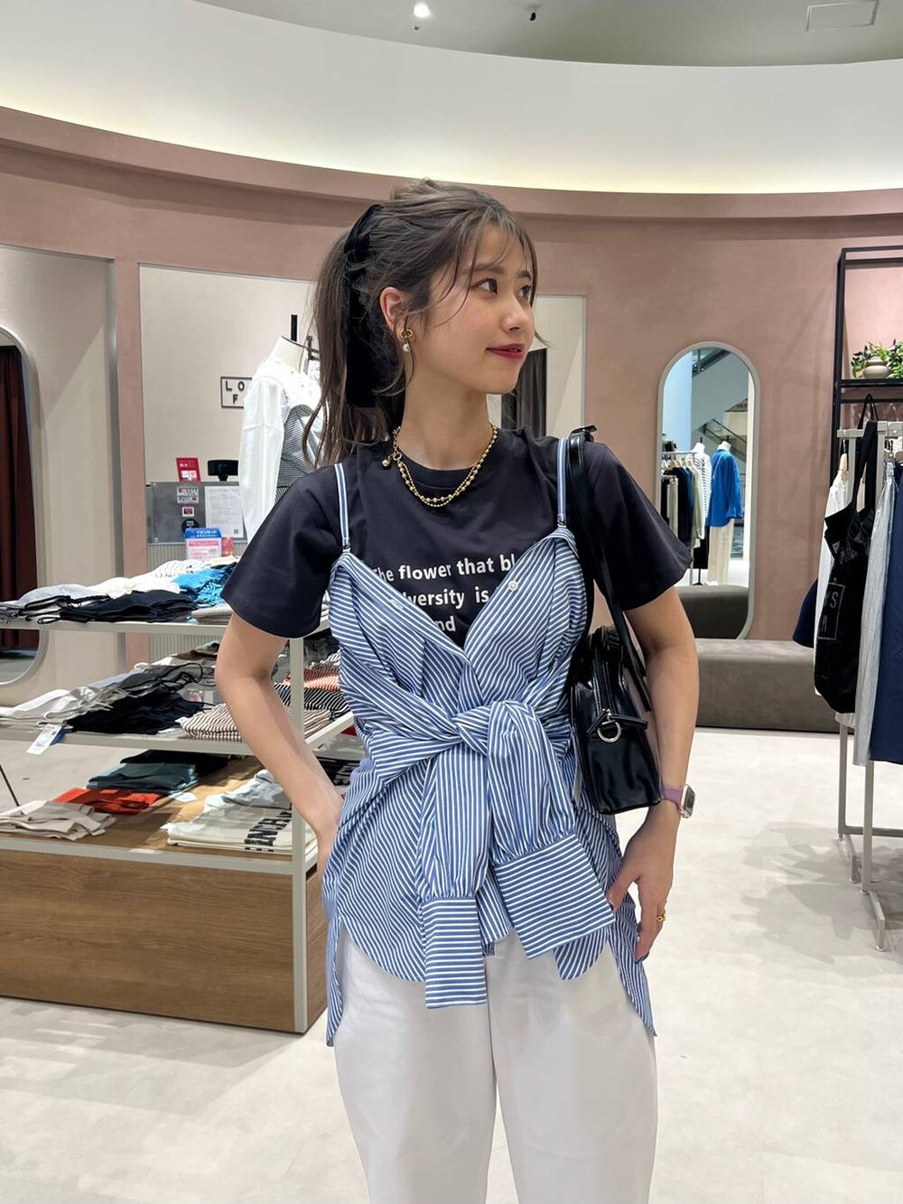 ブラック系のハンドバッグ、ブラック系のバレエシューズ、ブルー系のシャツ/ブラウスを着用したレディースの春コーディネートの3枚目の写真