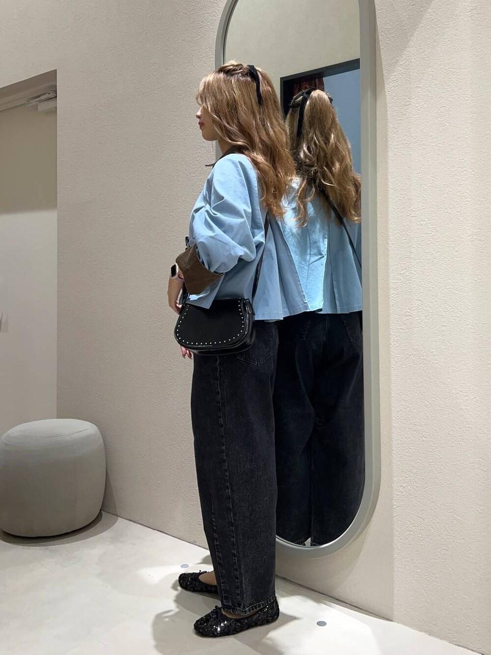 ブラック系のデニムパンツ、ブラック系のバレエシューズ、ホワイト系のキャミソールを着用したレディースの秋コーディネートの2枚目の写真