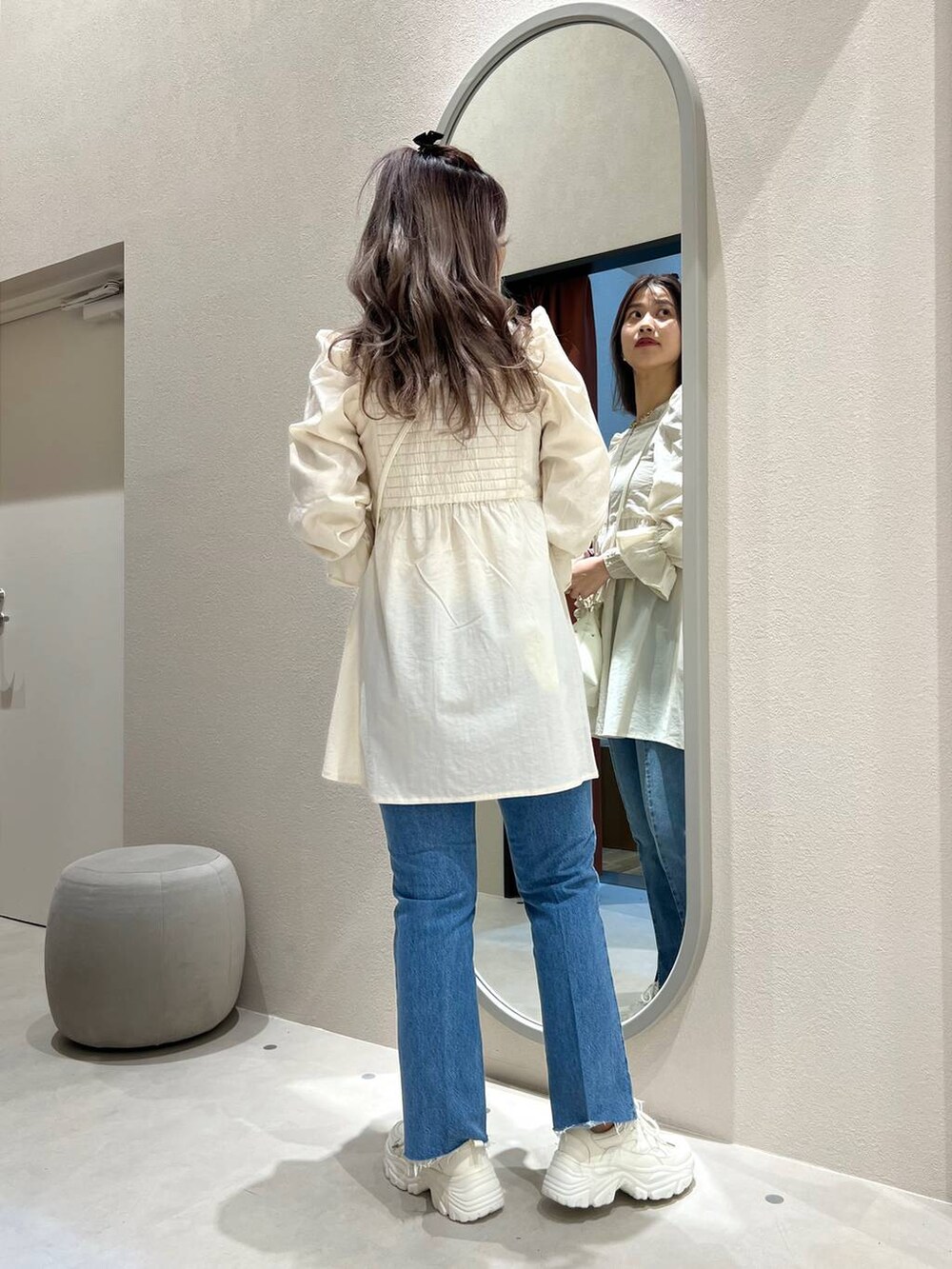 ベージュ系のハンドバッグ、ホワイト系のスニーカー、ベージュ系のTシャツ/カットソーを着用したレディースの冬コーディネートの3枚目の写真