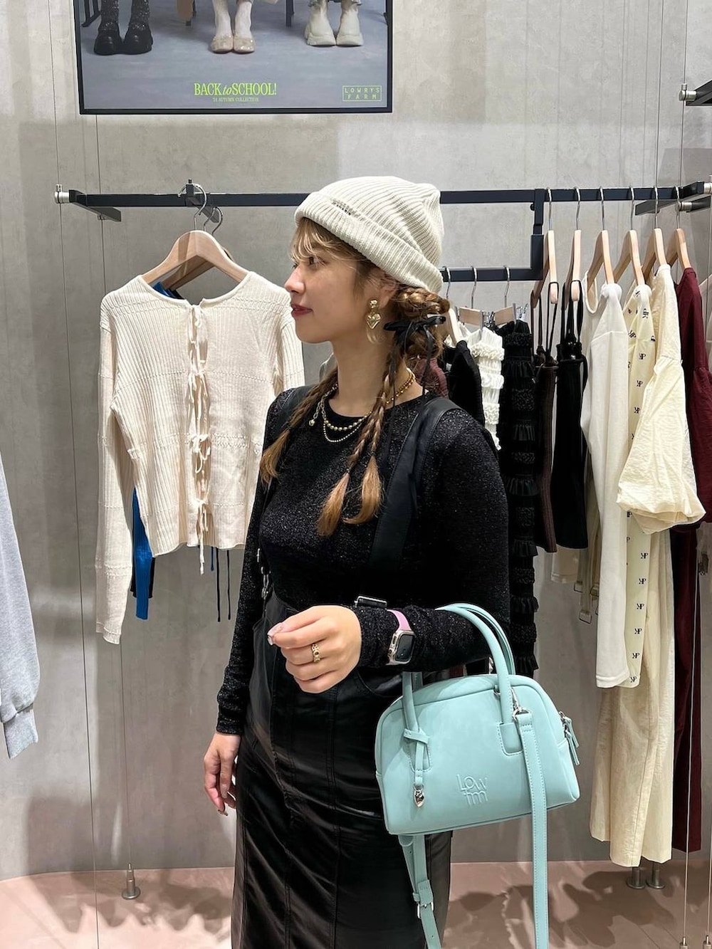 ブラック系のTシャツ/カットソー、シルバー系のボストンバッグ、ブラック系のジャンパースカートを着用したレディースの秋コーディネートの3枚目の写真