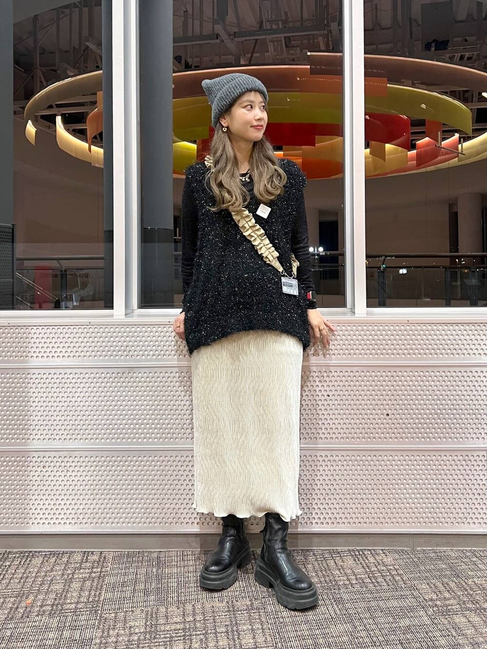 ホワイト系のスカート、ブラック系のニット/セーター、ブラック系のTシャツ/カットソーを着用したレディースの冬コーディネートの2枚目の写真