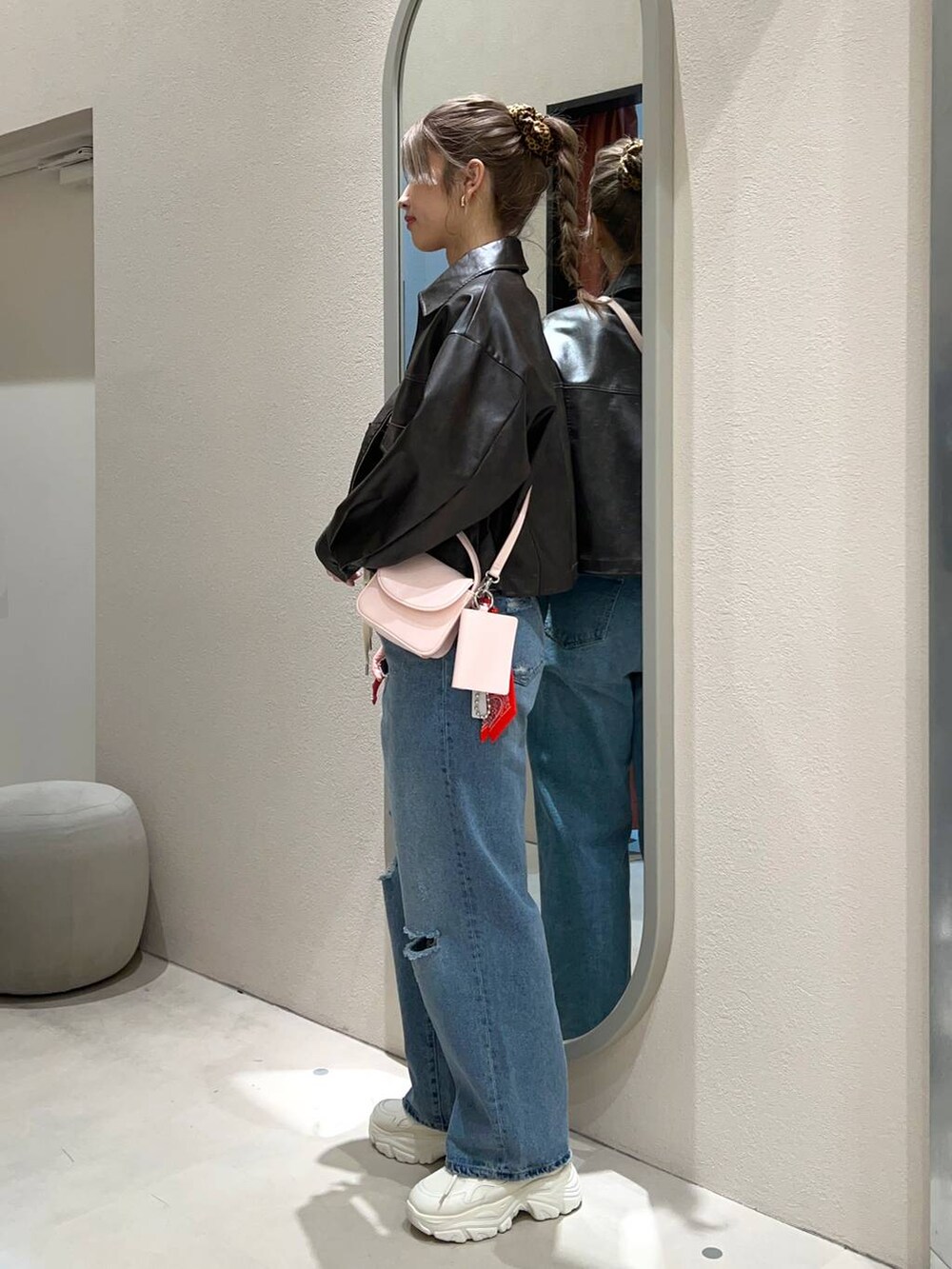 ブルー系のデニムパンツ、シルバー系のショルダーバッグ、ホワイト系のニット/セーターを着用したレディースの冬コーディネートの2枚目の写真