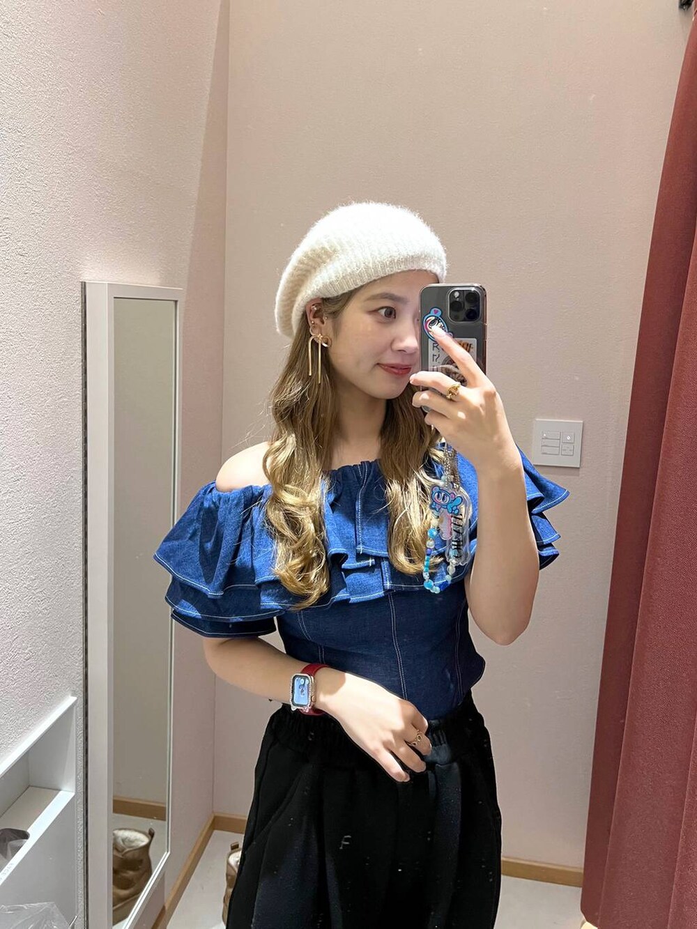 ブラウン系のショルダーバッグ、ホワイト系のスラックス、ホワイト系のスニーカーを着用したレディースの冬コーディネートの3枚目の写真