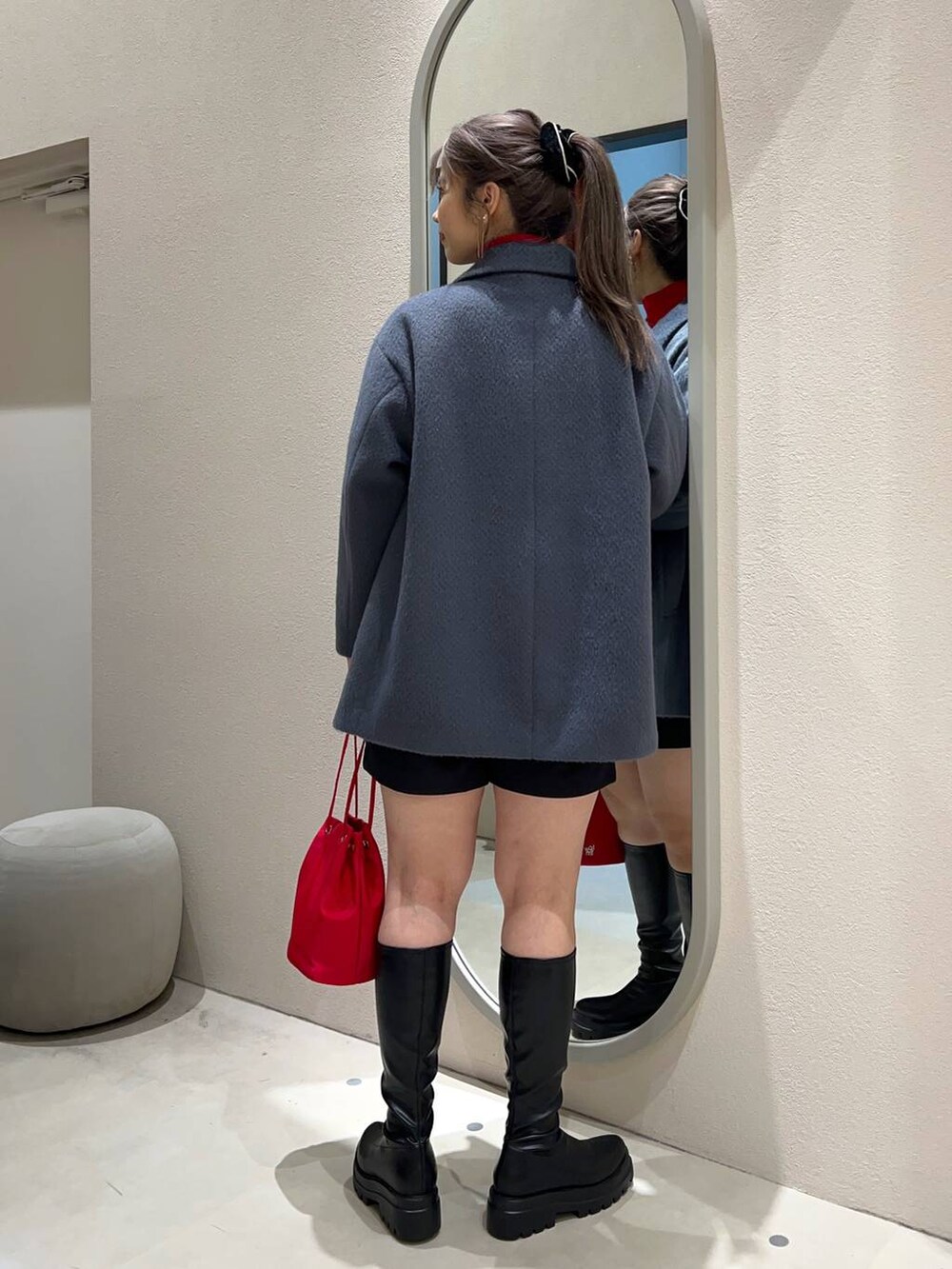 ブラック系のブーツ、グレー系のスウェット、レッド系のハンドバッグを着用したレディースの冬コーディネートの3枚目の写真