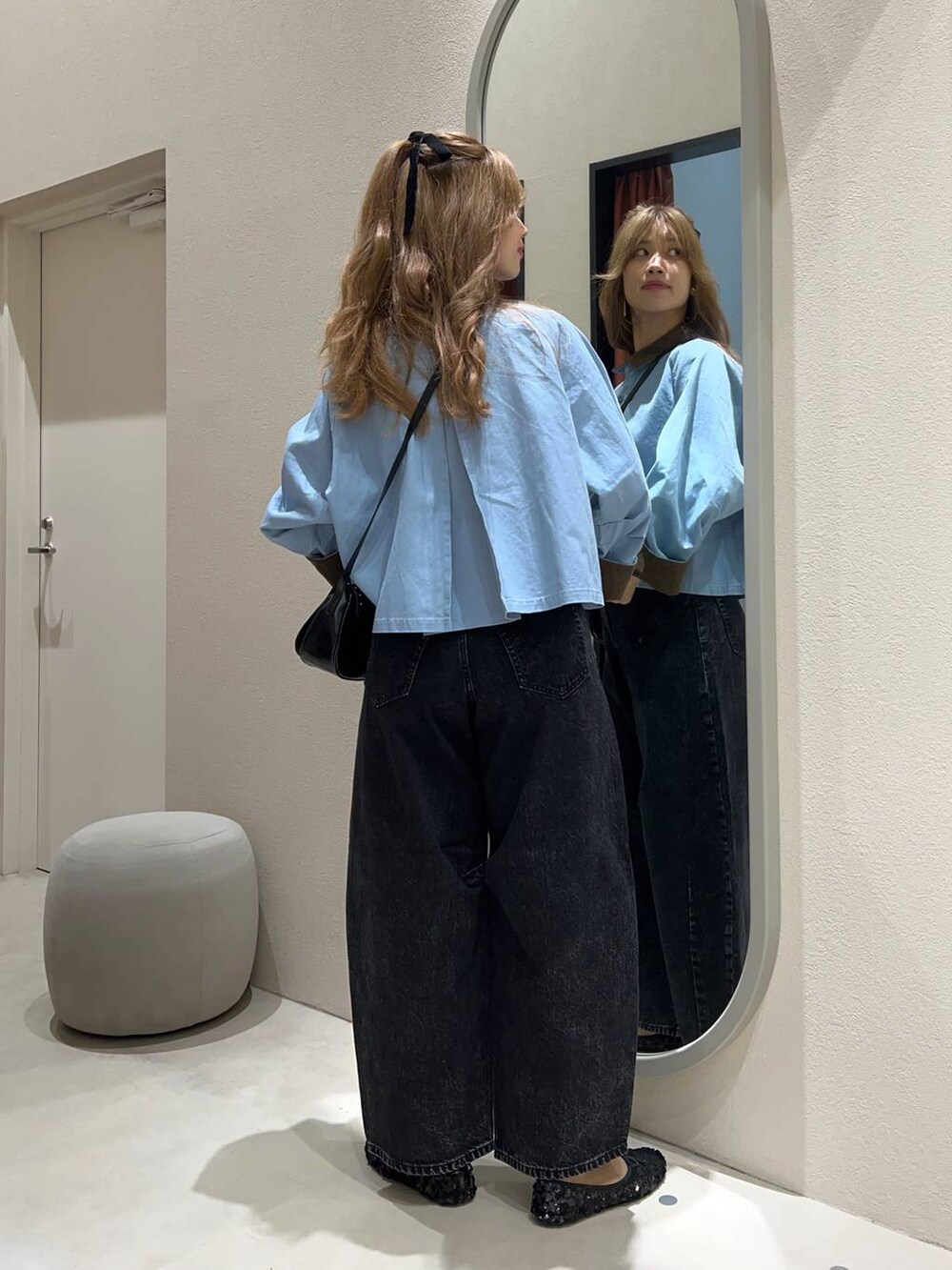 ブラック系のデニムパンツ、ブラック系のバレエシューズ、ホワイト系のキャミソールを着用したレディースの秋コーディネートの3枚目の写真