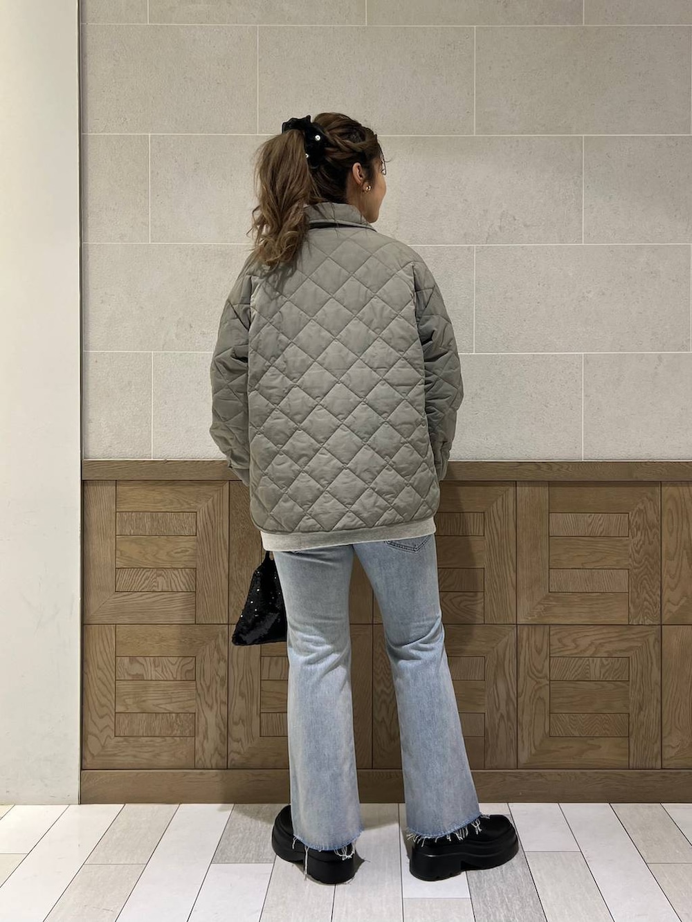 ブラック系のブーツ、ブラック系のハンドバッグ、グリーン系のブルゾンを着用したレディースの冬コーディネートの3枚目の写真