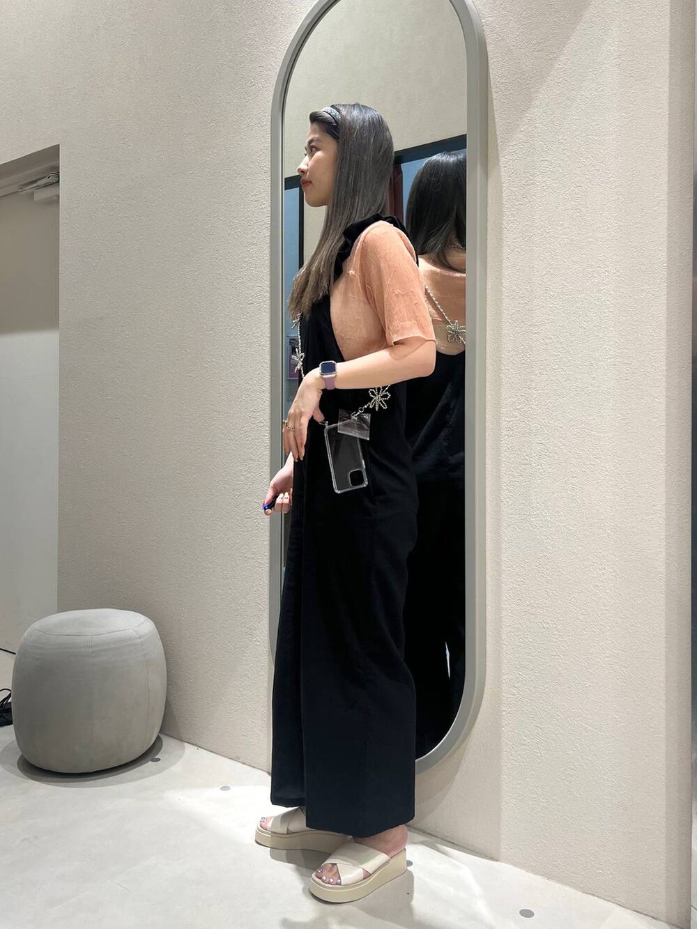 ホワイト系のサンダル、ブラック系のサロペット/オーバーオール、オレンジ系のTシャツ/カットソーを着用したレディースの春コーディネートの3枚目の写真