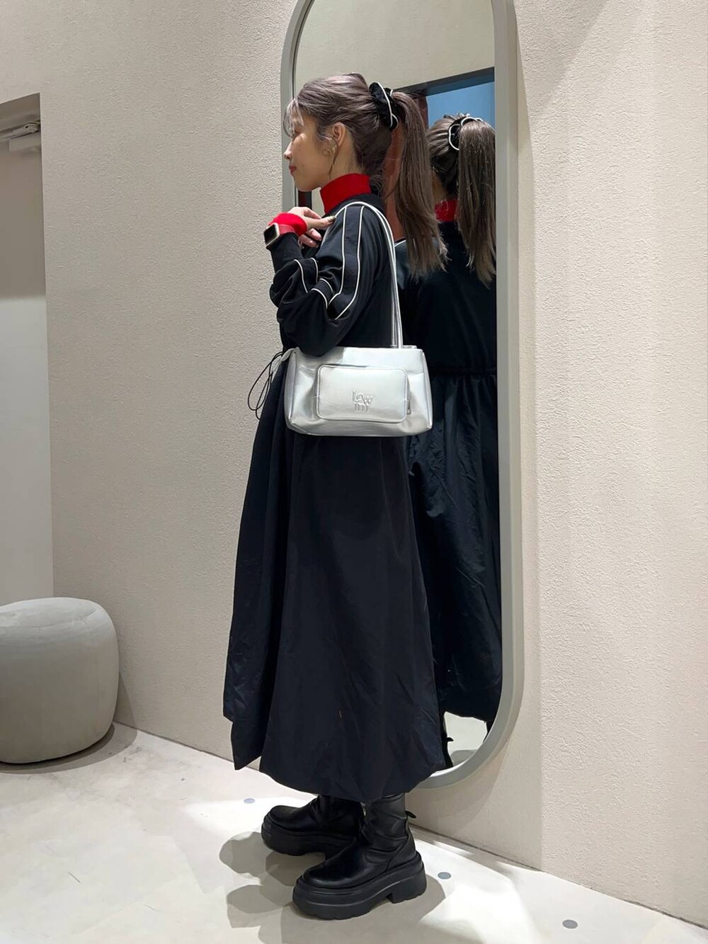 レッド系のニット/セーター、シルバー系のショルダーバッグ、ブラック系のワンピースを着用したレディースの冬コーディネートの3枚目の写真