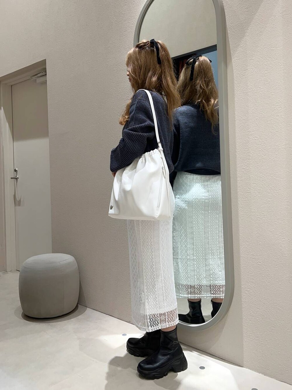 ブラック系のブーツ、ホワイト系のショルダーバッグ、ブルー系のワンピースを着用したレディースの秋コーディネートの2枚目の写真