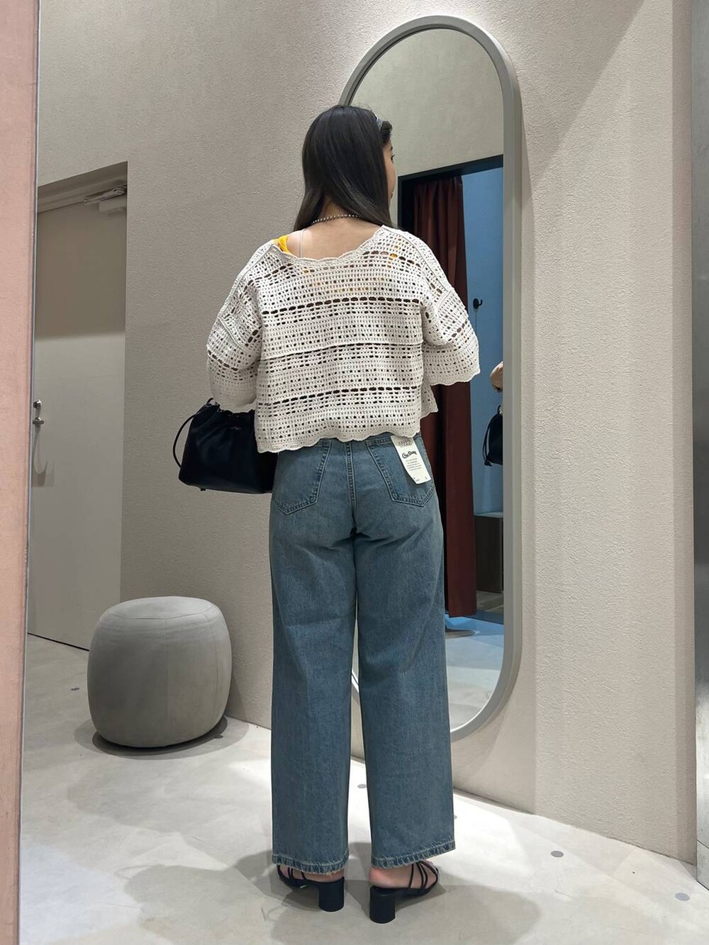 ブラック系のサンダル、シルバー系のショルダーバッグ、ブルー系のデニムパンツを着用したレディースの春コーディネートの3枚目の写真