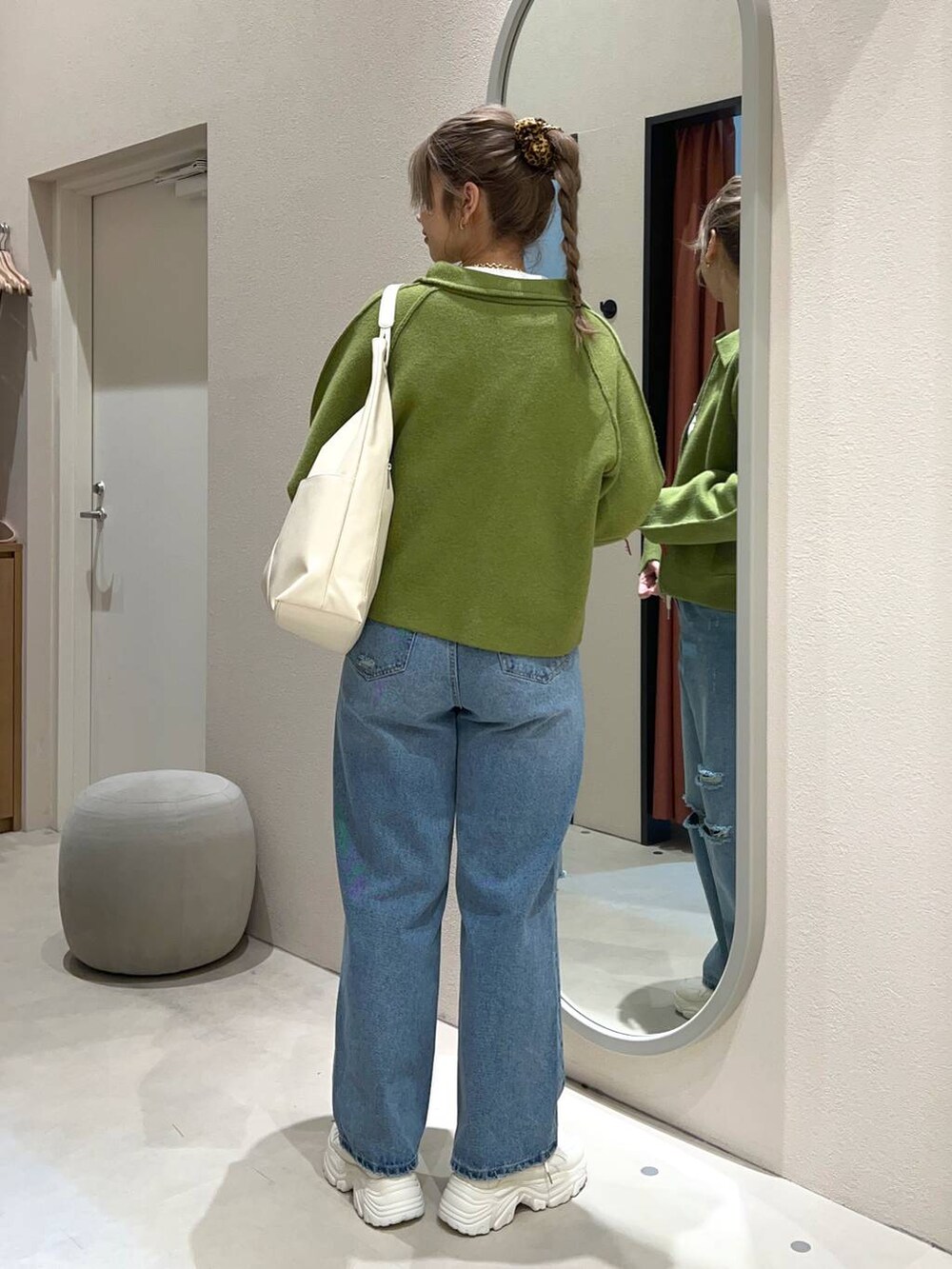 ホワイト系のTシャツ/カットソー、ブルー系のデニムパンツ、ホワイト系のトートバッグを着用したレディースの冬コーディネートの4枚目の写真