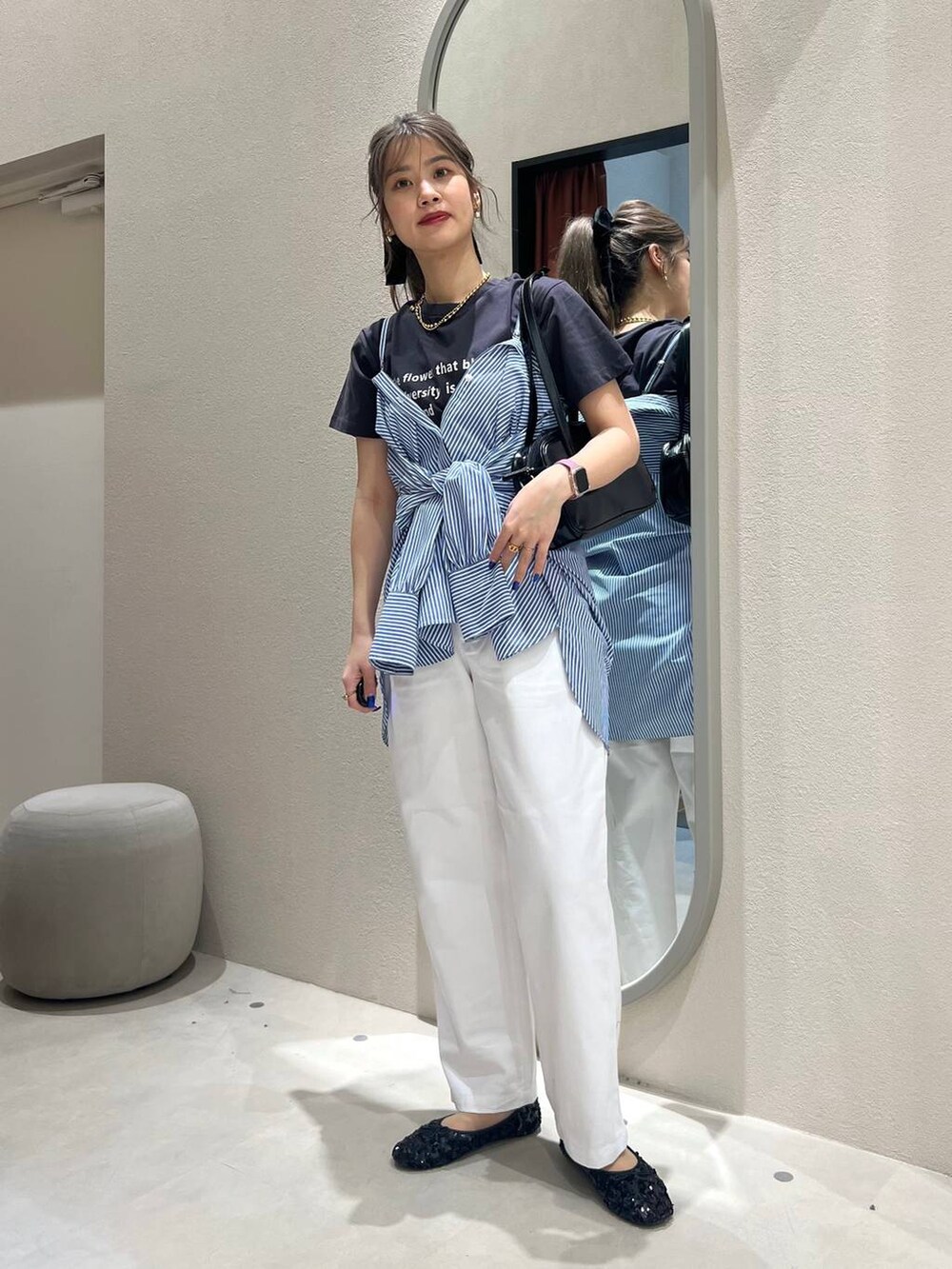 ブラック系のハンドバッグ、ブラック系のバレエシューズ、ブルー系のシャツ/ブラウスを着用したレディースの春コーディネートの2枚目の写真