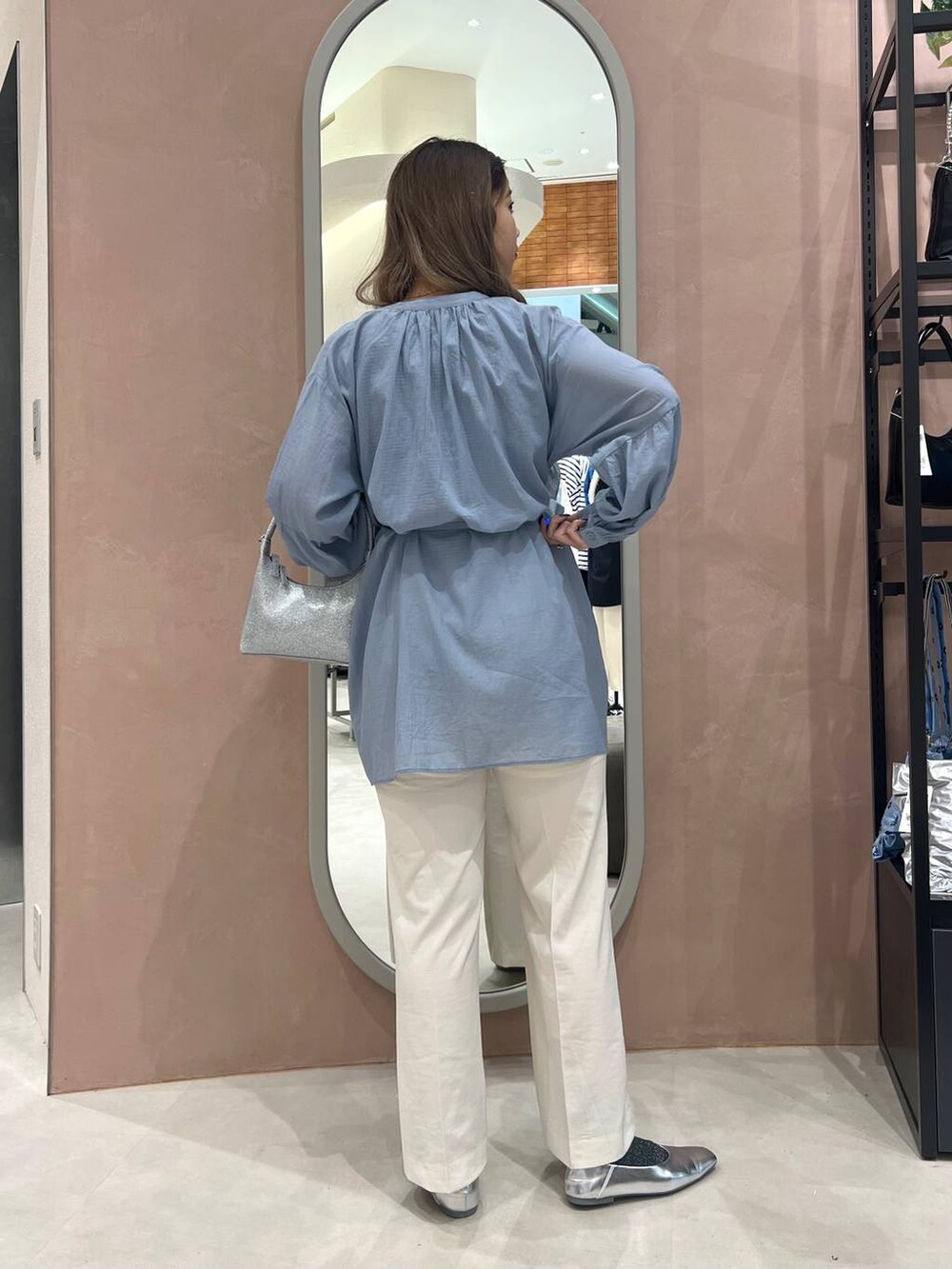 シルバー系のパンプス、ブラック系のタンクトップ、シルバー系のハンドバッグを着用したレディースの春コーディネートの2枚目の写真