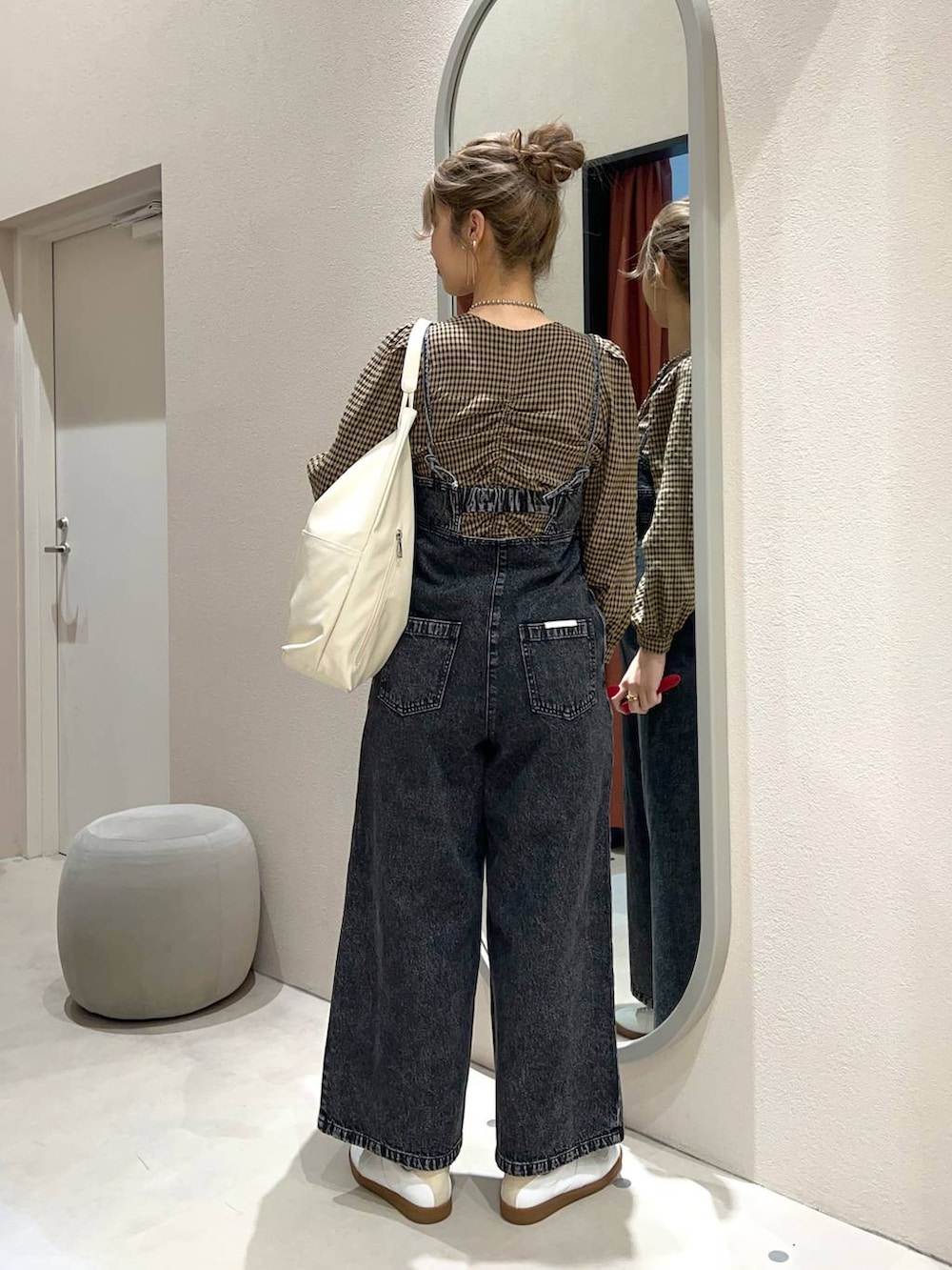 ブラック系のサロペット/オーバーオール、ホワイト系のトートバッグ、ホワイト系のスニーカーを着用したレディースの冬コーディネートの3枚目の写真