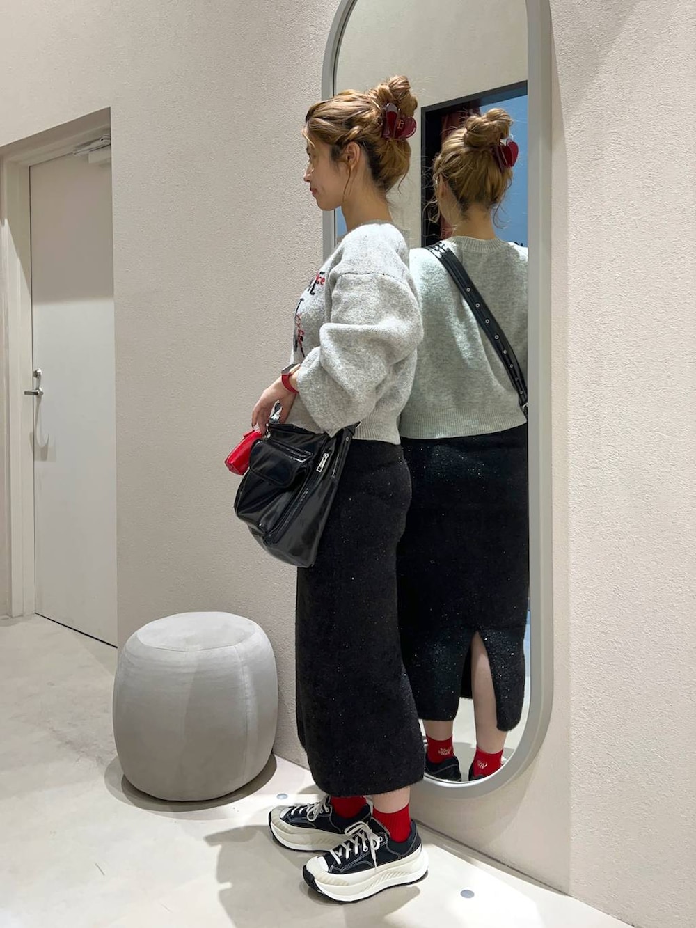 ブラック系のその他アウター、その他のショルダーバッグ、グレー系のニット/セーターを着用したレディースの冬コーディネートの3枚目の写真