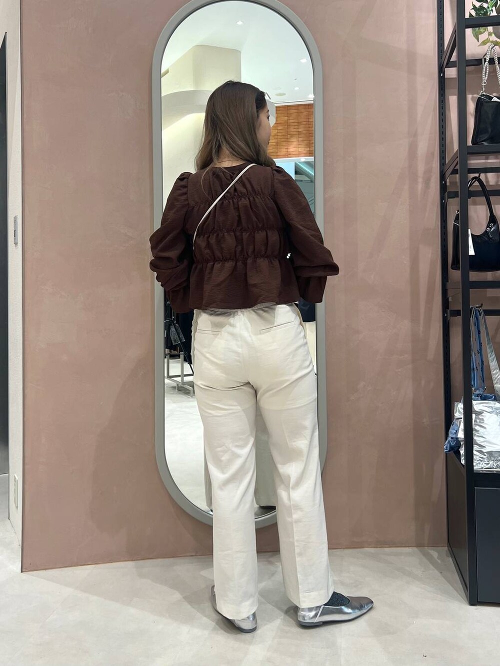 シルバー系のパンプス、シルバー系のショルダーバッグ、ブラック系のタンクトップを着用したレディースの春コーディネートの3枚目の写真