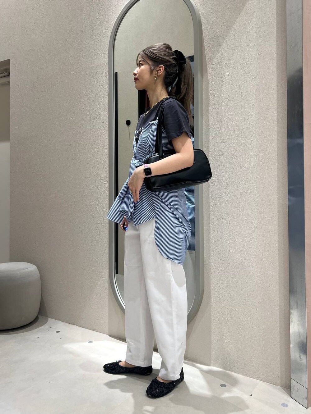 ブラック系のハンドバッグ、ブラック系のバレエシューズ、ブルー系のシャツ/ブラウスを着用したレディースの春コーディネートの4枚目の写真