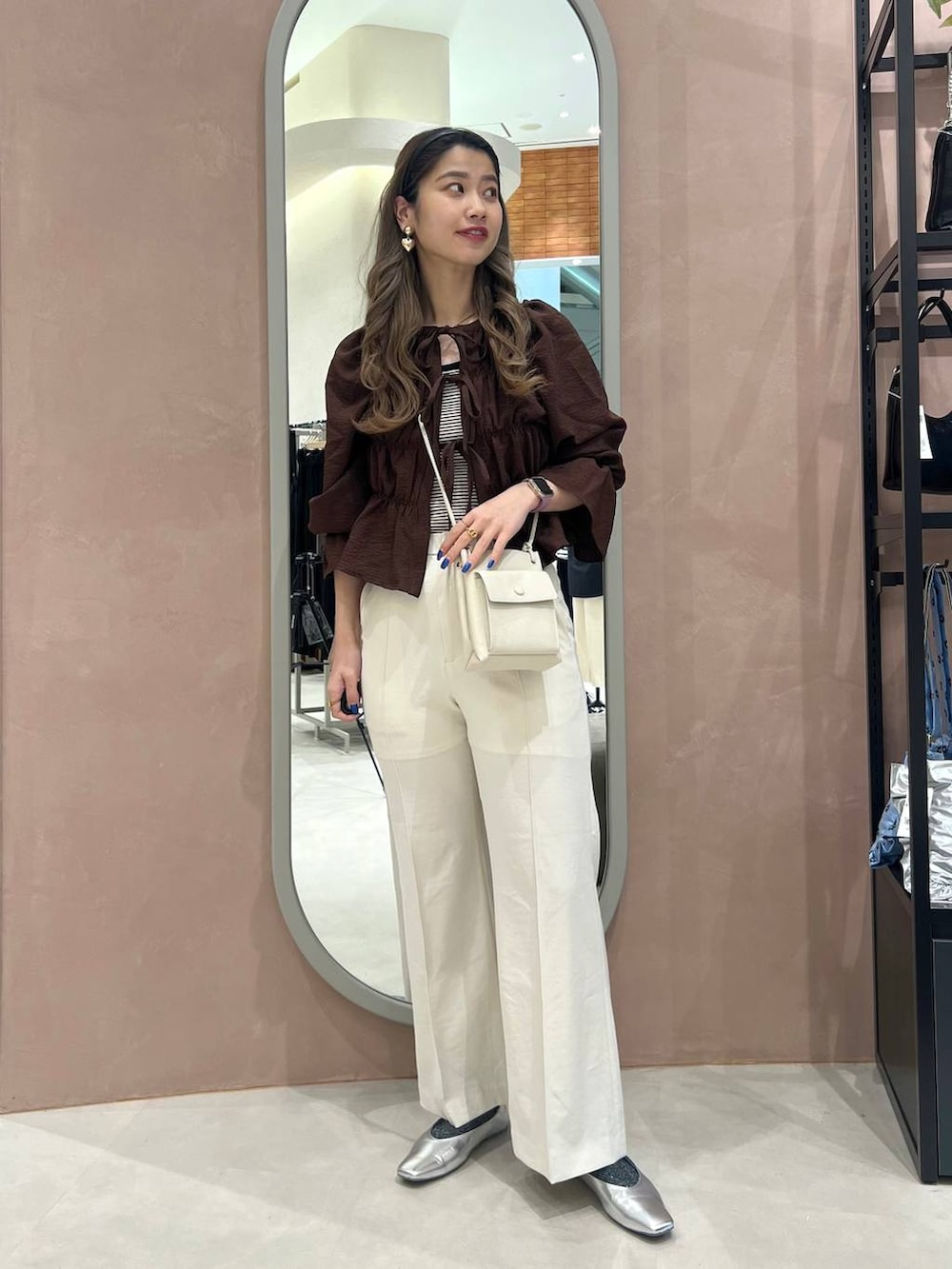 シルバー系のパンプス、シルバー系のショルダーバッグ、ブラック系のタンクトップを着用したレディースの春コーディネートの2枚目の写真