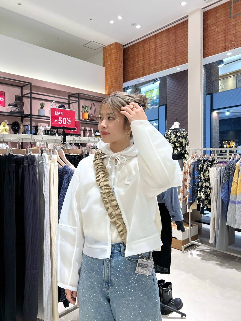 ブルー系のデニムパンツ、ホワイト系のニット/セーター、ホワイト系のパーカーを着用したレディースの冬コーディネートの4枚目の写真