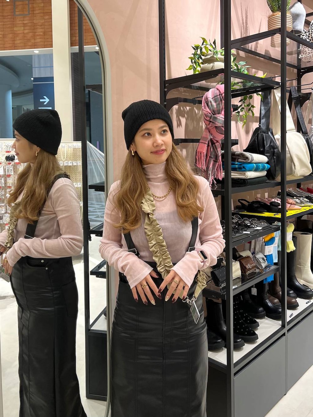 ブラック系のジャンパースカート、ピンク系のTシャツ/カットソー、ベージュ系のネックレスを着用したレディースの秋コーディネートの2枚目の写真