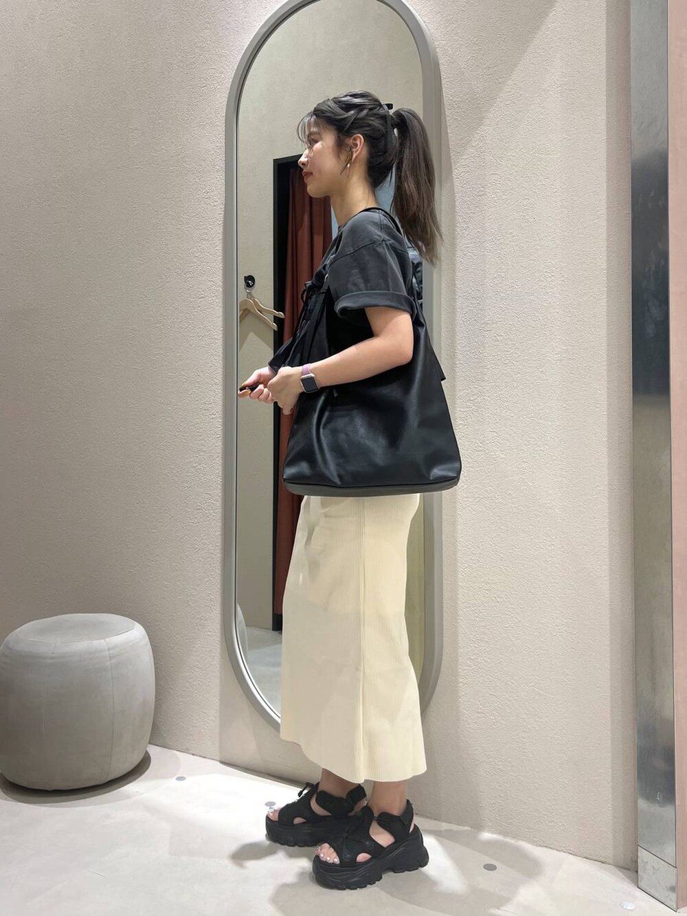 ホワイト系のスカート、ブラック系のサンダル、グレー系のTシャツ/カットソーを着用したレディースの春コーディネートの2枚目の写真