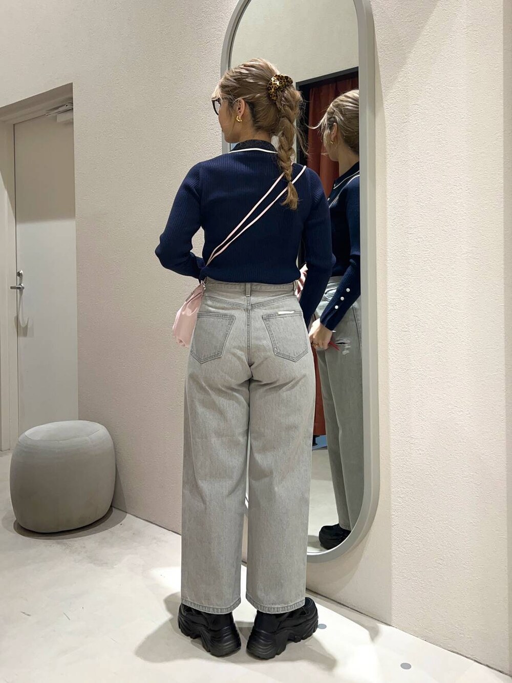 グレー系のデニムパンツ、ブラック系のスニーカー、ピンク系のショルダーバッグを着用したレディースの冬コーディネートの4枚目の写真