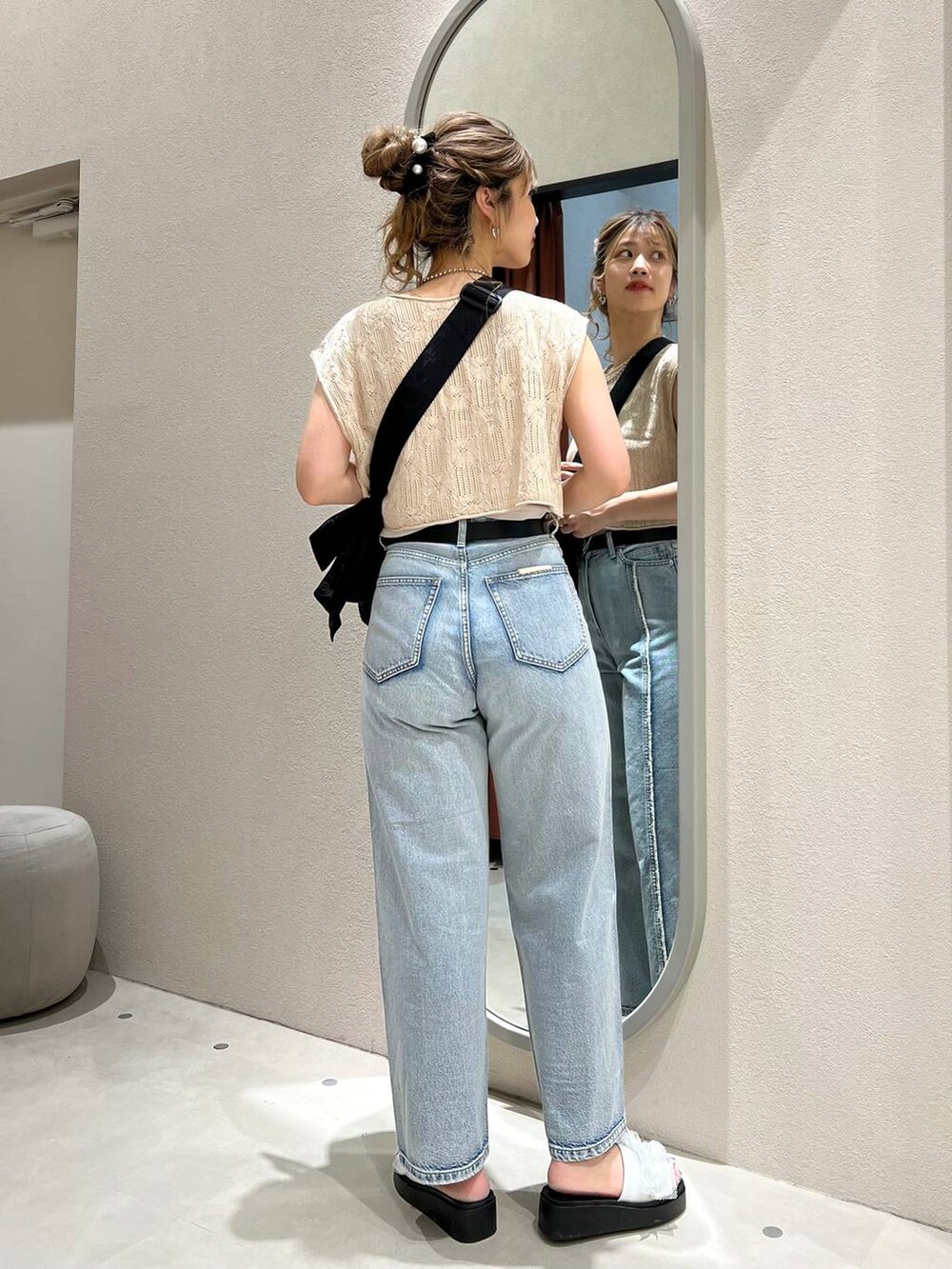 ホワイト系のサンダル、ブラック系のショルダーバッグ、ブルー系のデニムパンツを着用したレディースの夏コーディネートの4枚目の写真