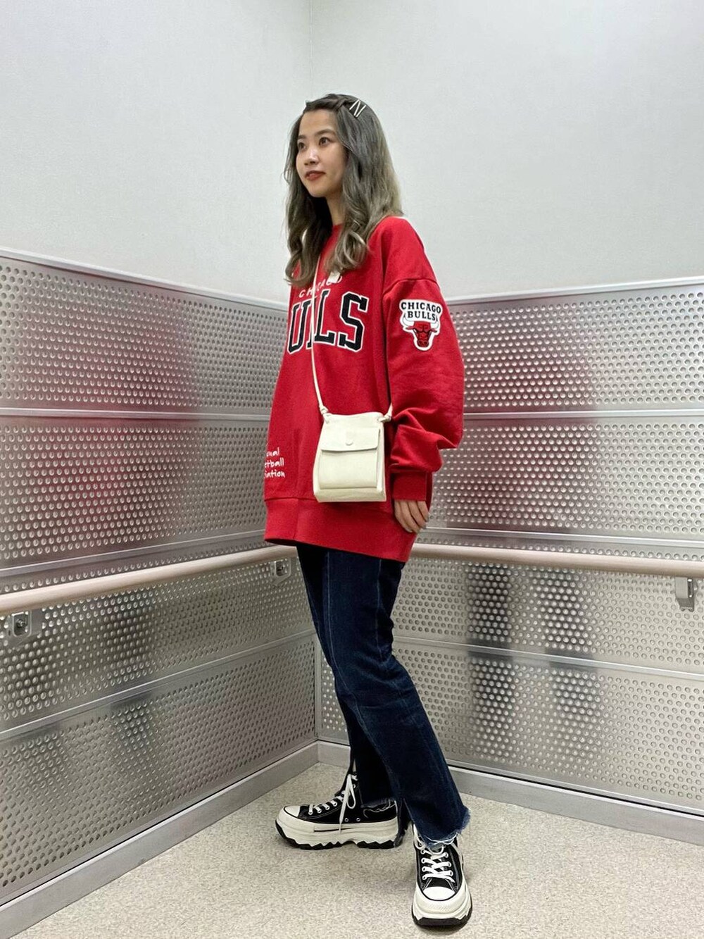 ホワイト系のショルダーバッグ、ブルー系のデニムパンツ、ブラック系のスウェットを着用したレディースの夏コーディネートの2枚目の写真