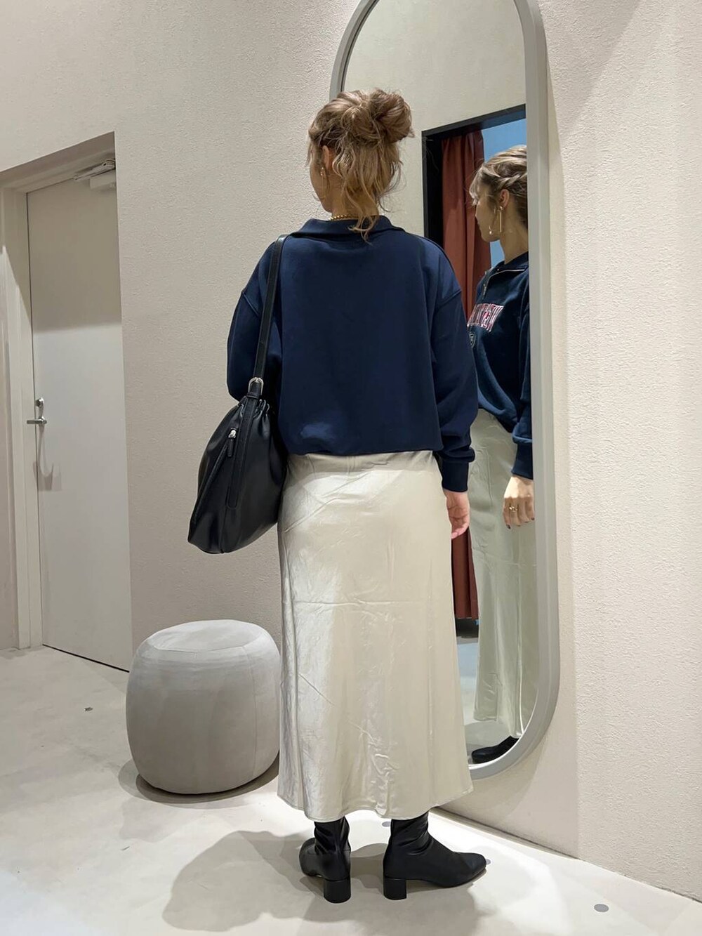 ホワイト系のスカート、ブラック系のブーツ、ブルー系のスウェットを着用したレディースの秋コーディネートの3枚目の写真