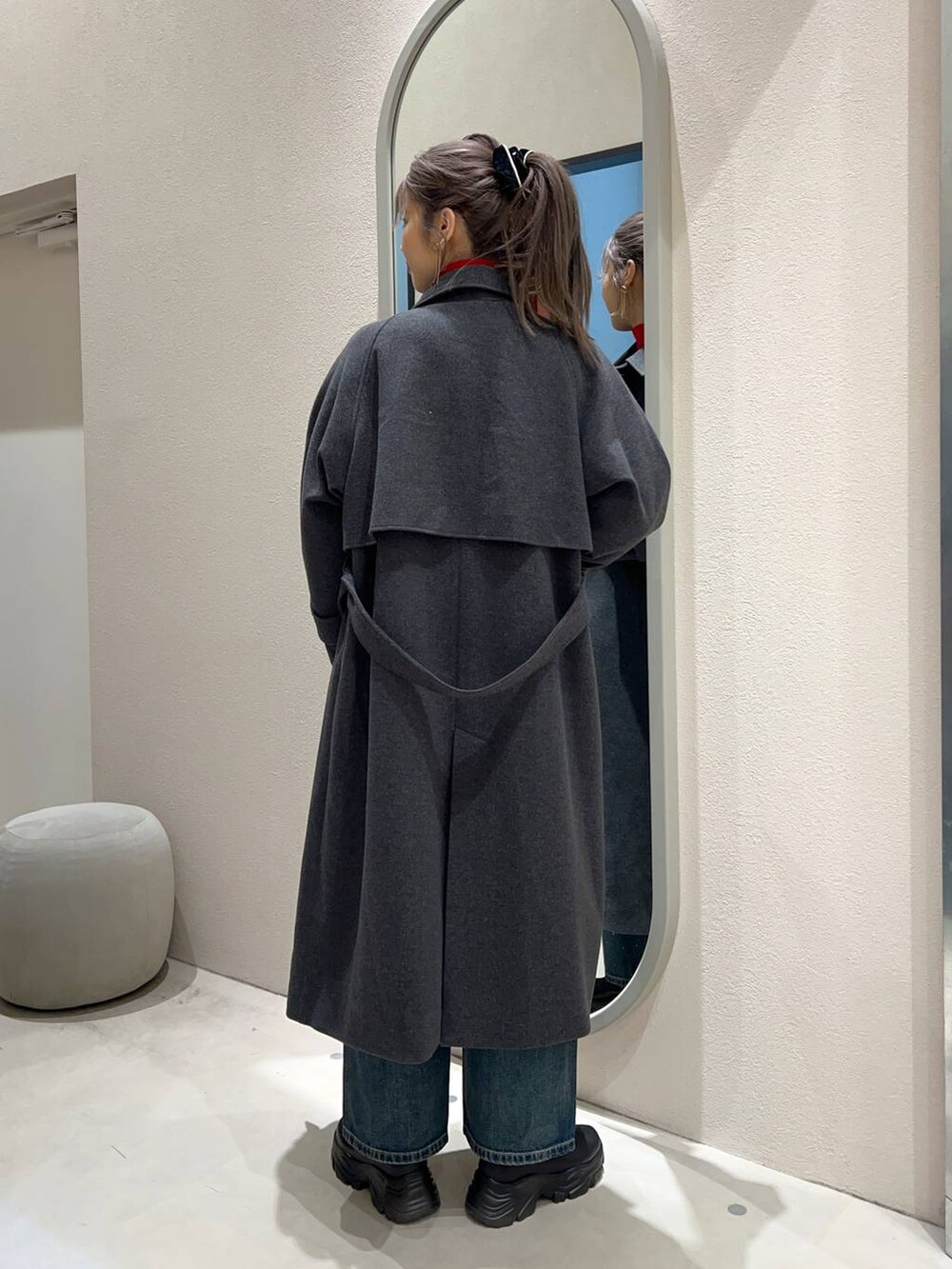 レッド系のニット/セーター、ブラック系のブーツ、ブルー系のデニムパンツを着用したレディースの冬コーディネートの3枚目の写真