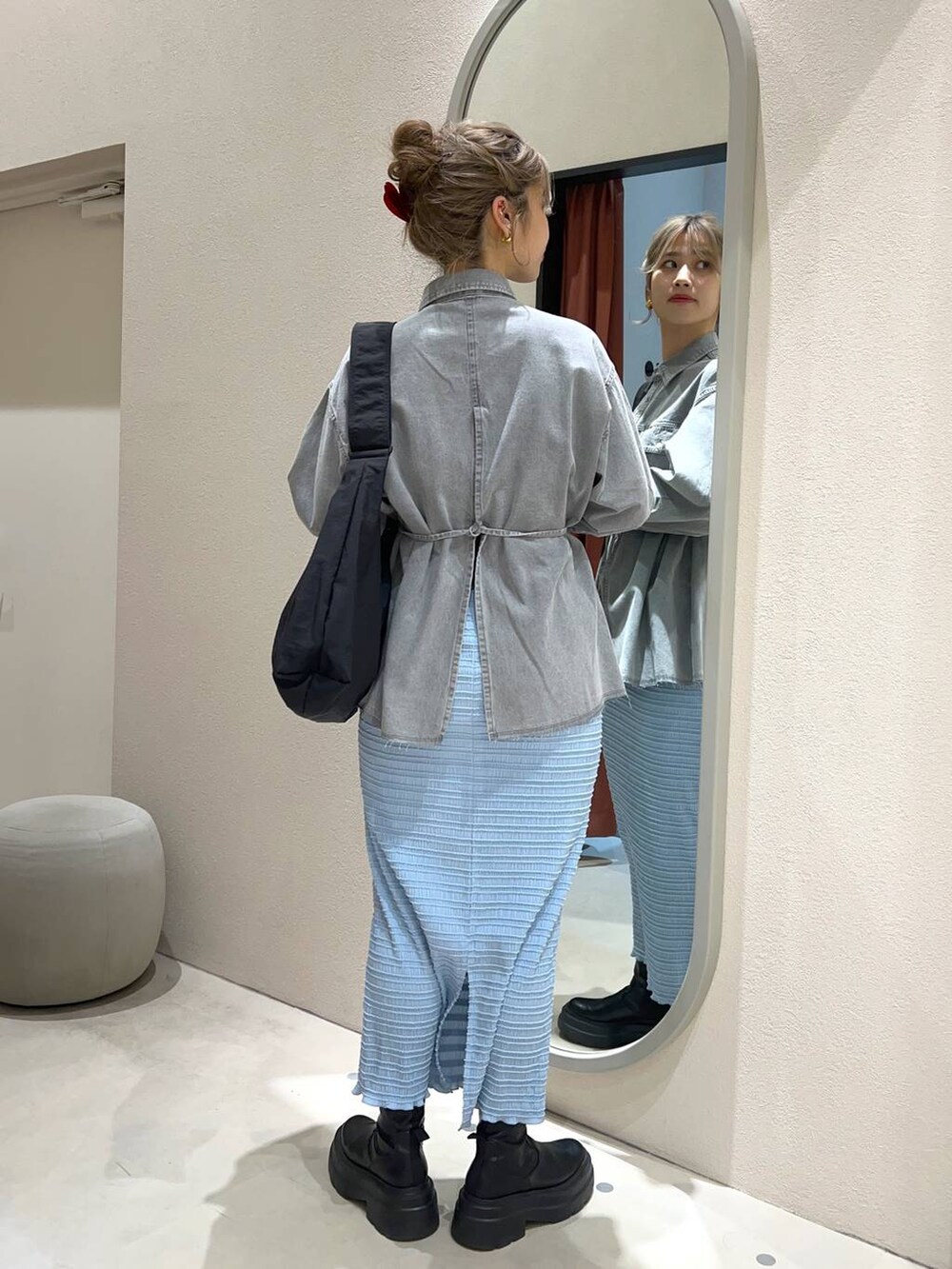 ブラック系のショルダーバッグ、グレー系のシャツ/ブラウス、ブルー系のスカートを着用したレディースの冬コーディネートの3枚目の写真