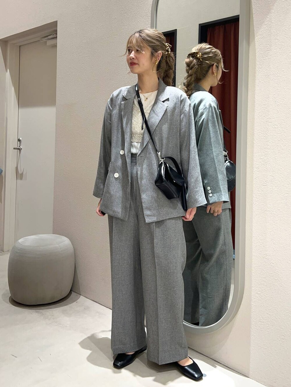 ベージュ系のTシャツ/カットソー、グレー系のスラックス、グレー系のテーラードジャケットを着用したレディースの冬コーディネートの2枚目の写真
