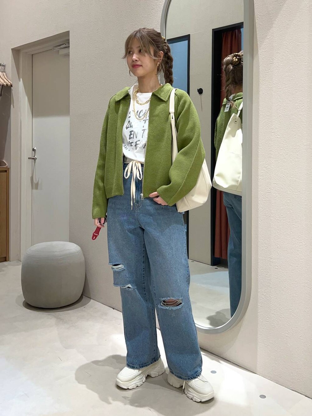 ホワイト系のTシャツ/カットソー、ブルー系のデニムパンツ、ホワイト系のトートバッグを着用したレディースの冬コーディネートの2枚目の写真