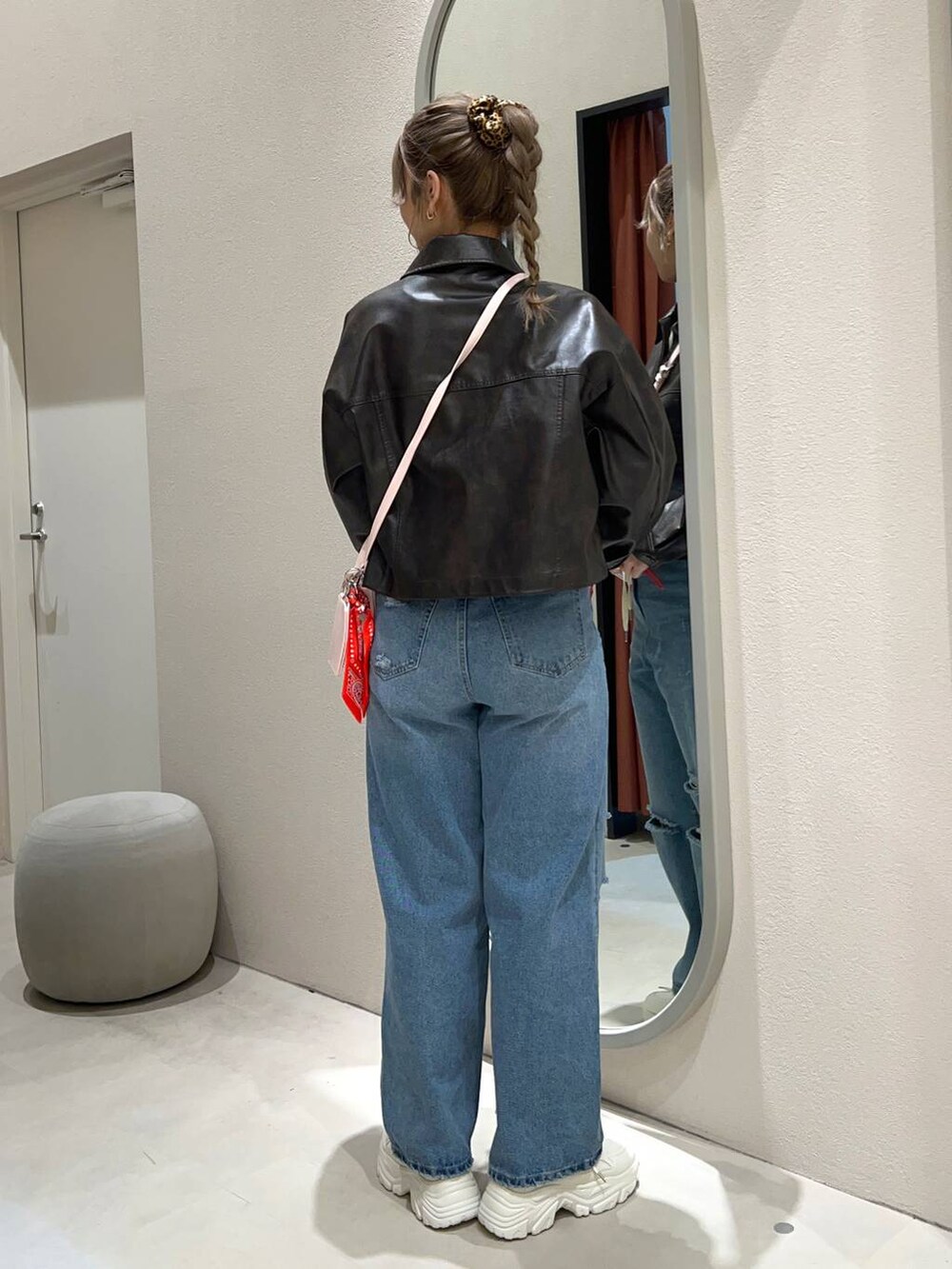 ブルー系のデニムパンツ、シルバー系のショルダーバッグ、ホワイト系のニット/セーターを着用したレディースの冬コーディネートの3枚目の写真
