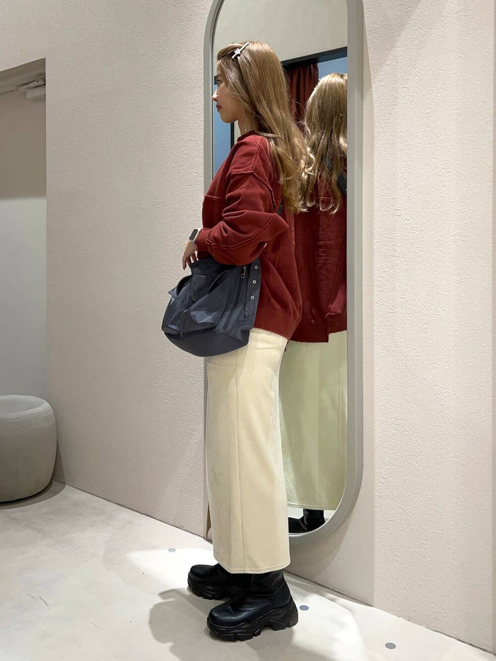 ブラック系のブーツ、グレー系のショルダーバッグ、ホワイト系のスカートを着用したレディースの秋コーディネートの3枚目の写真