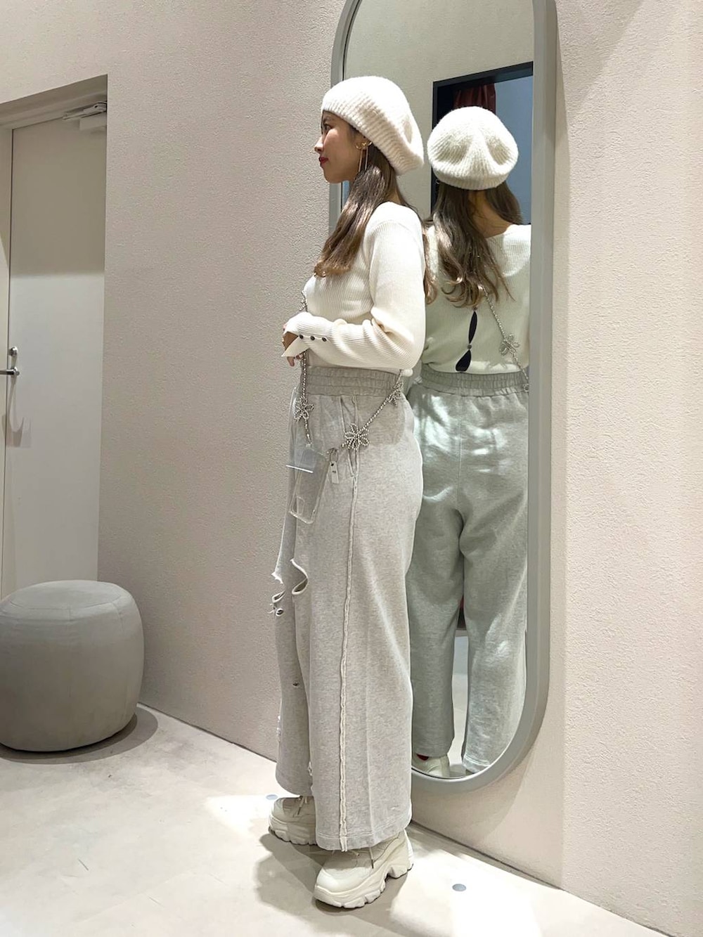 ホワイト系のスニーカー、ホワイト系のニット/セーター、グレー系のスウェットパンツを着用したレディースの冬コーディネートの2枚目の写真