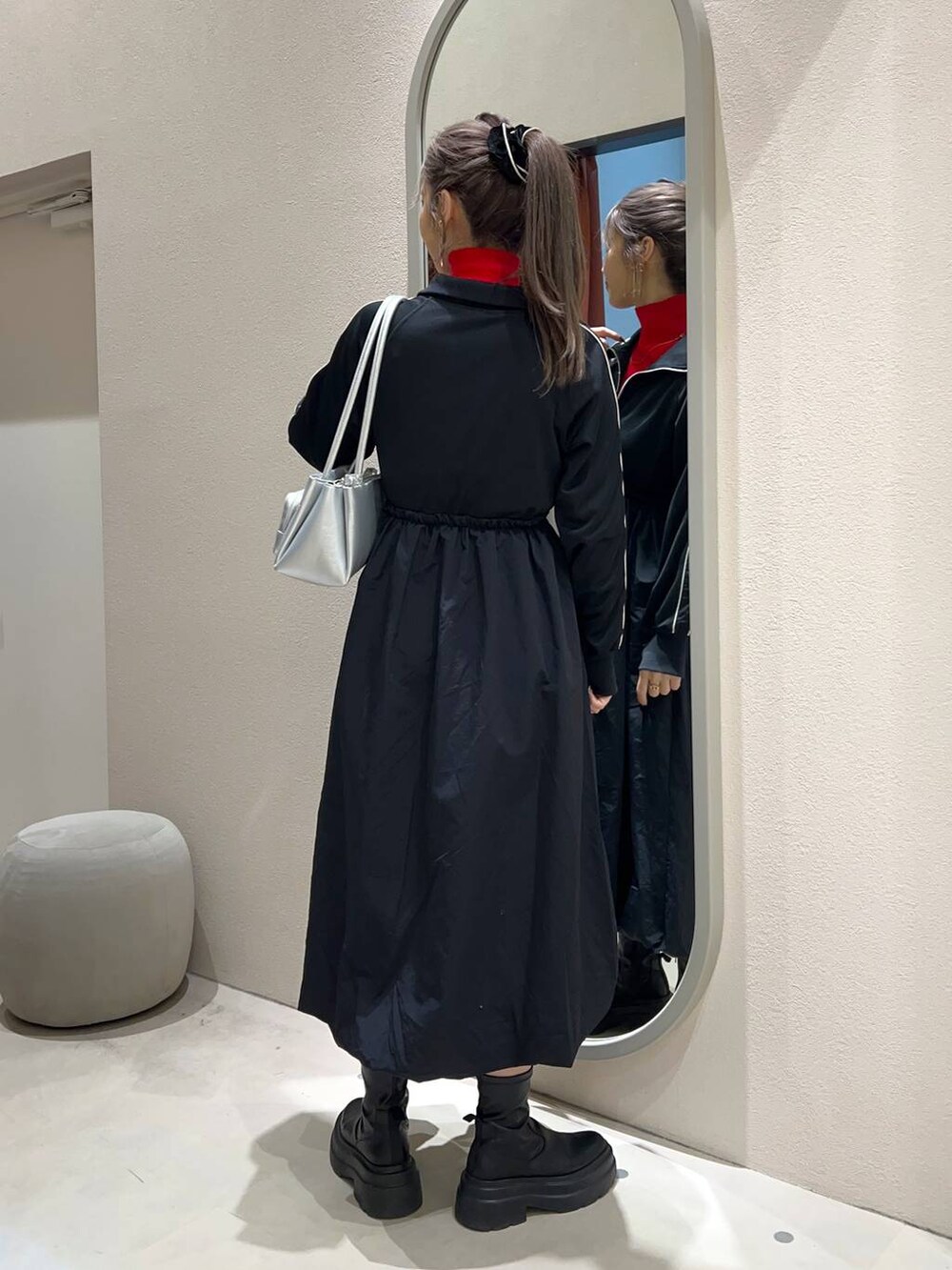 レッド系のニット/セーター、シルバー系のショルダーバッグ、ブラック系のワンピースを着用したレディースの冬コーディネートの4枚目の写真