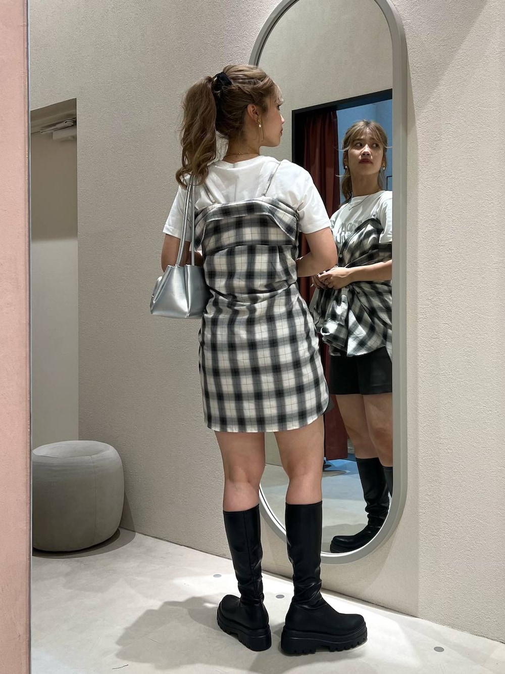 ホワイト系のシャツ/ブラウス、ブラック系のブーツ、ピンク系のショルダーバッグを着用したレディースの秋コーディネートの3枚目の写真