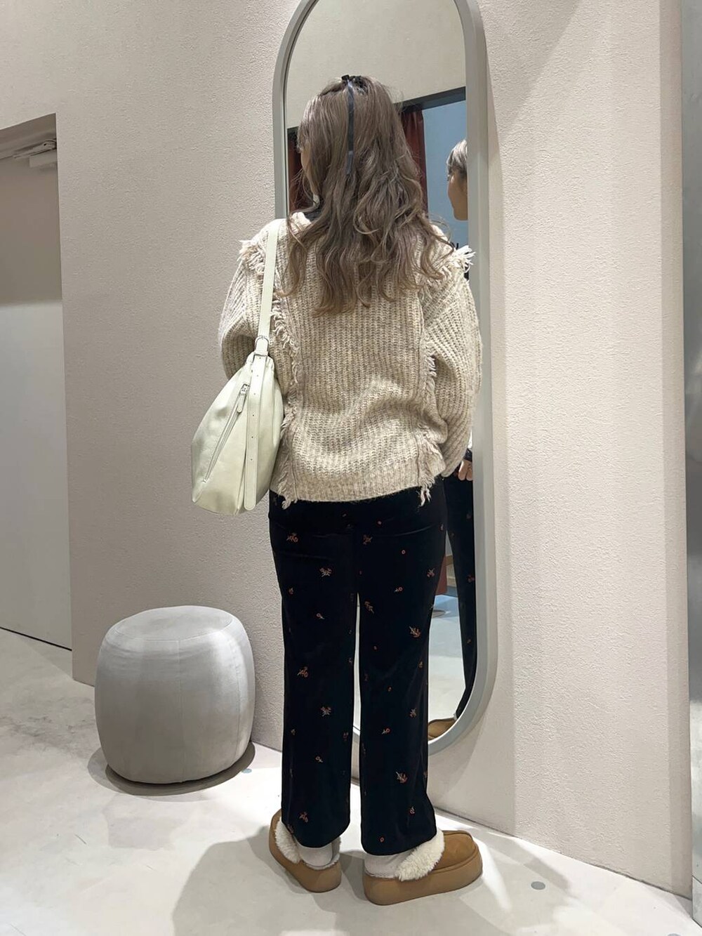 ホワイト系のニット/セーター、ホワイト系のショルダーバッグ、ブラック系のTシャツ/カットソーを着用したレディースの冬コーディネートの3枚目の写真