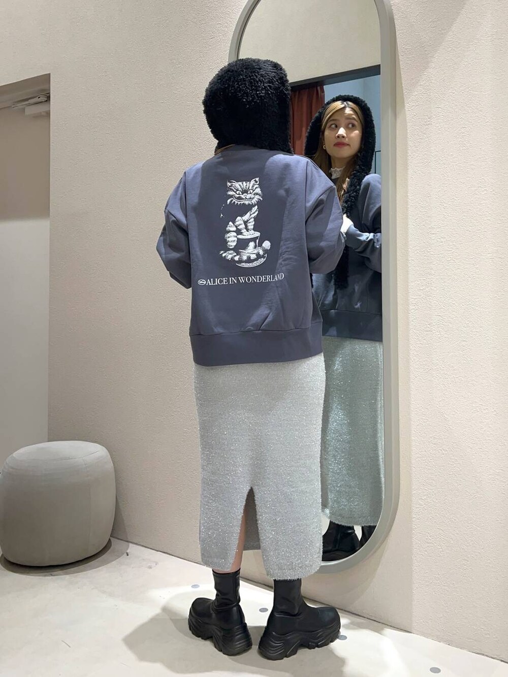 ブラック系のブーツ、グレー系のスカート、ホワイト系のTシャツ/カットソーを着用したレディースの冬コーディネートの3枚目の写真