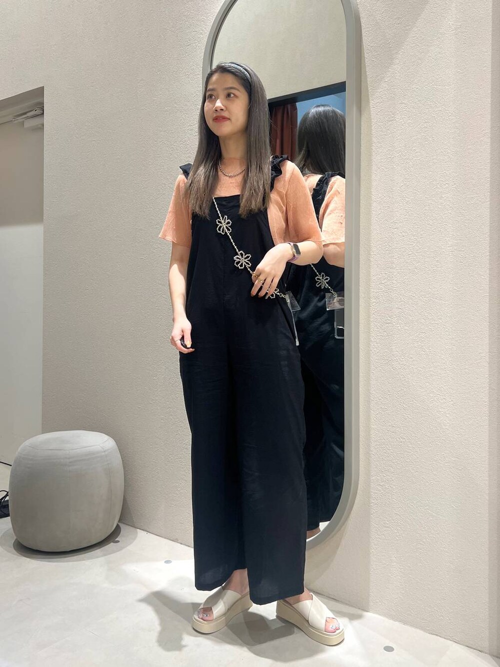 ホワイト系のサンダル、ブラック系のサロペット/オーバーオール、オレンジ系のTシャツ/カットソーを着用したレディースの春コーディネートの2枚目の写真