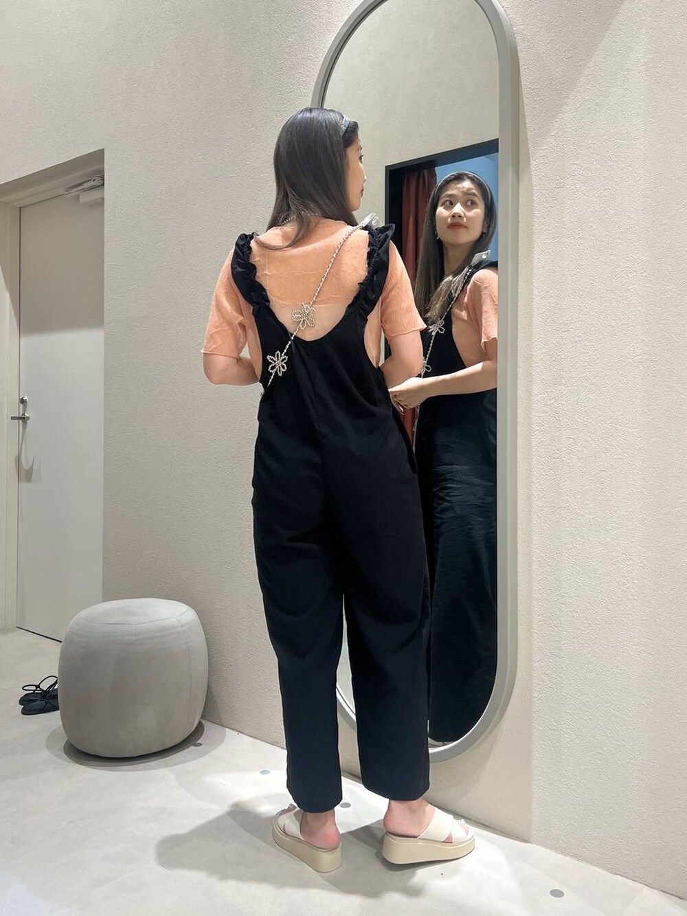 ホワイト系のサンダル、ブラック系のサロペット/オーバーオール、オレンジ系のTシャツ/カットソーを着用したレディースの春コーディネートの4枚目の写真